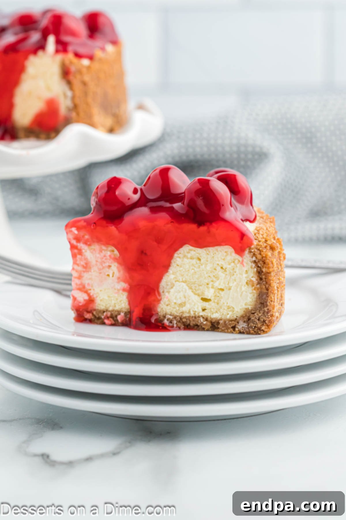 Slice of air fryer cheesecake on a plate with cherry topping.