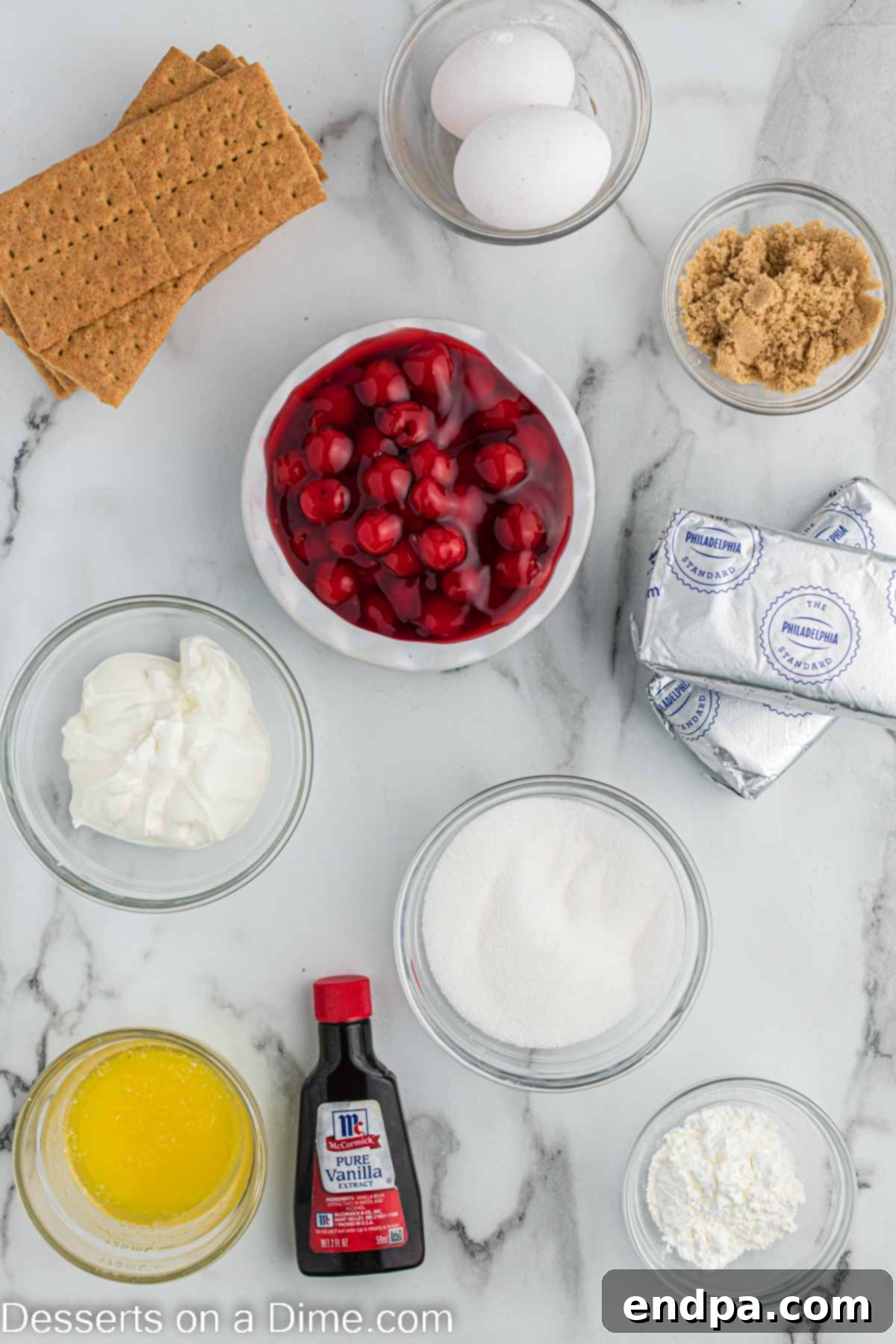 Ingredients for air fryer cheesecake - graham cracker sheets, butter, brown sugar, cream cheese, vanilla, eggs, cornstarch, cherry pie filling.