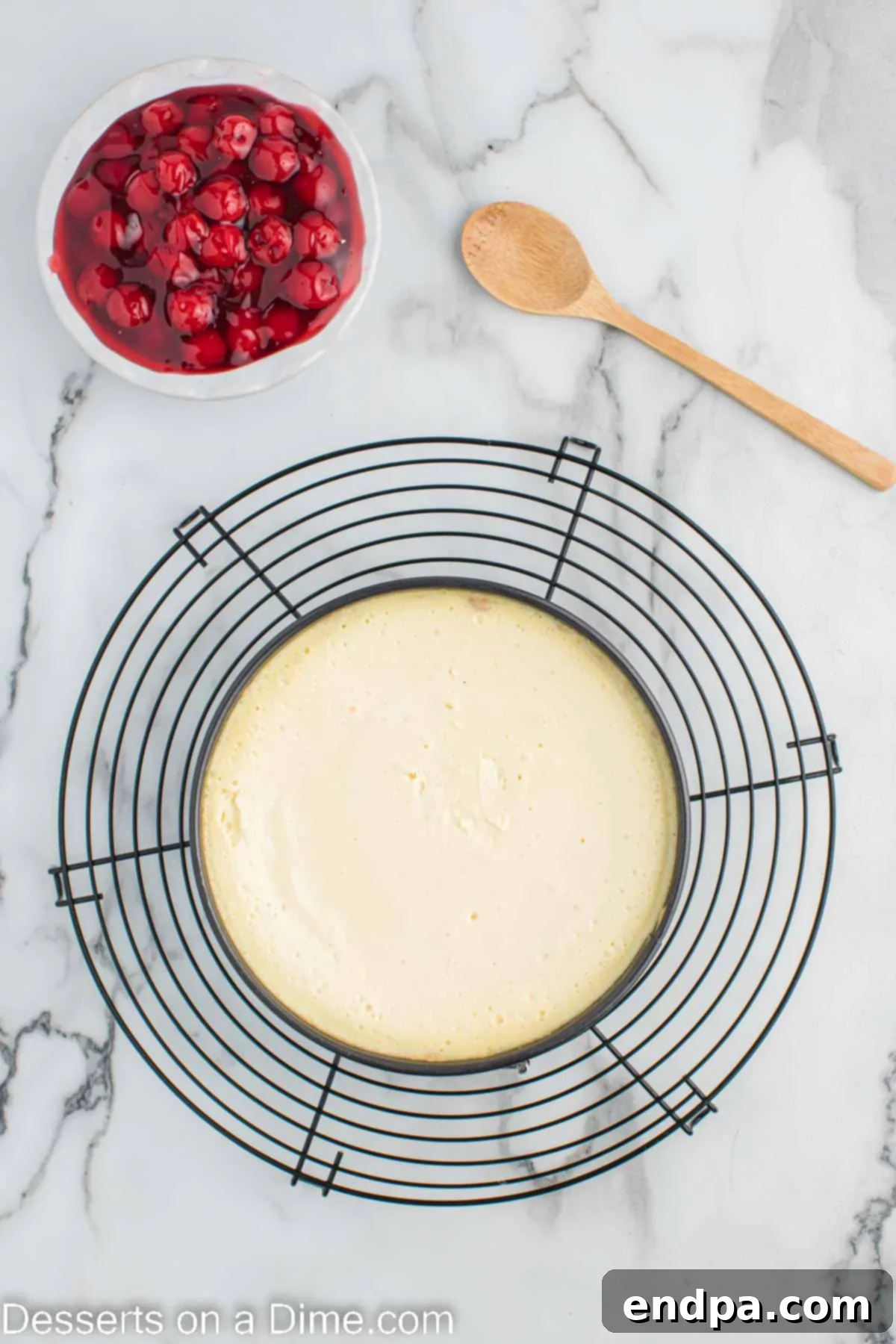 Cheesecake cooling on wire rack.
