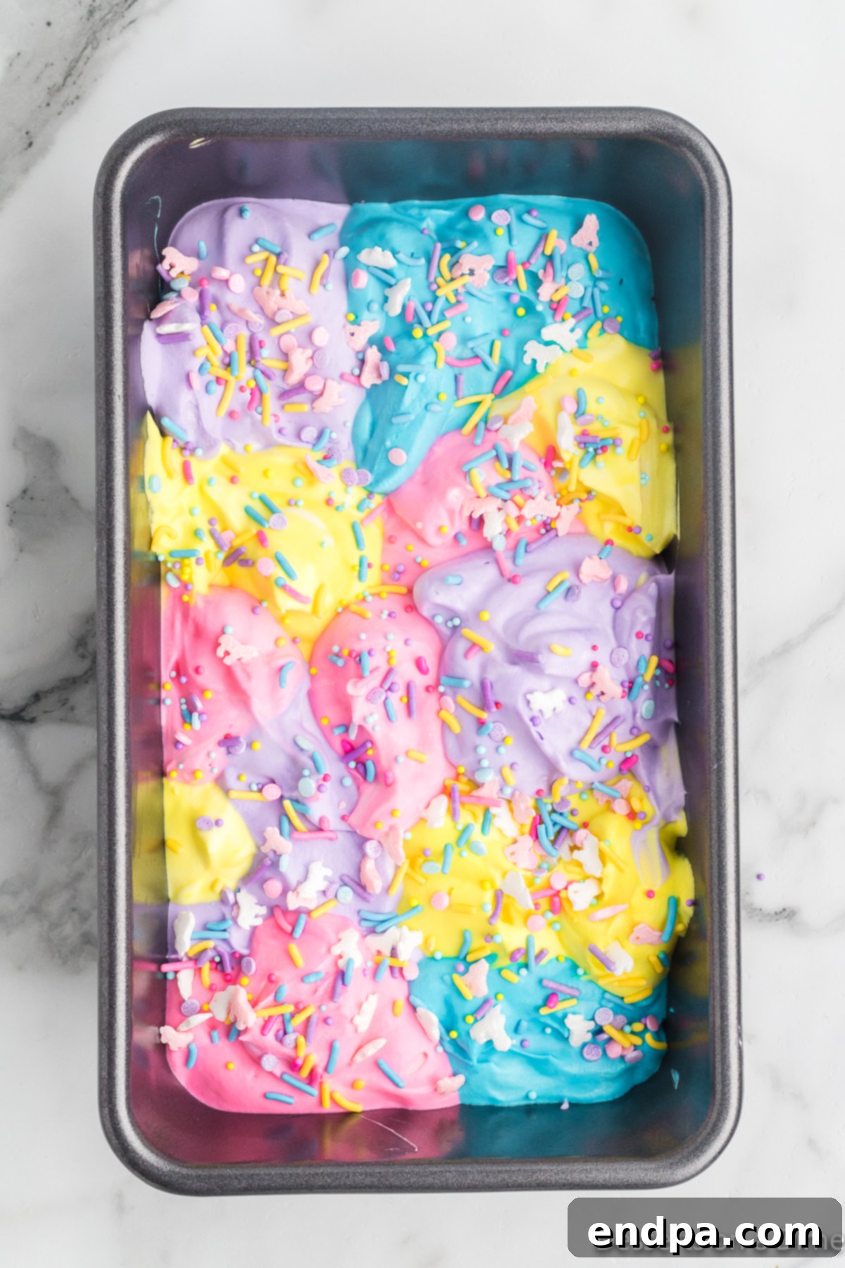 Rainbow Unicorn Dream 8 Unicorn sprinkles scattered on top of the first layer of colored ice cream mixture.