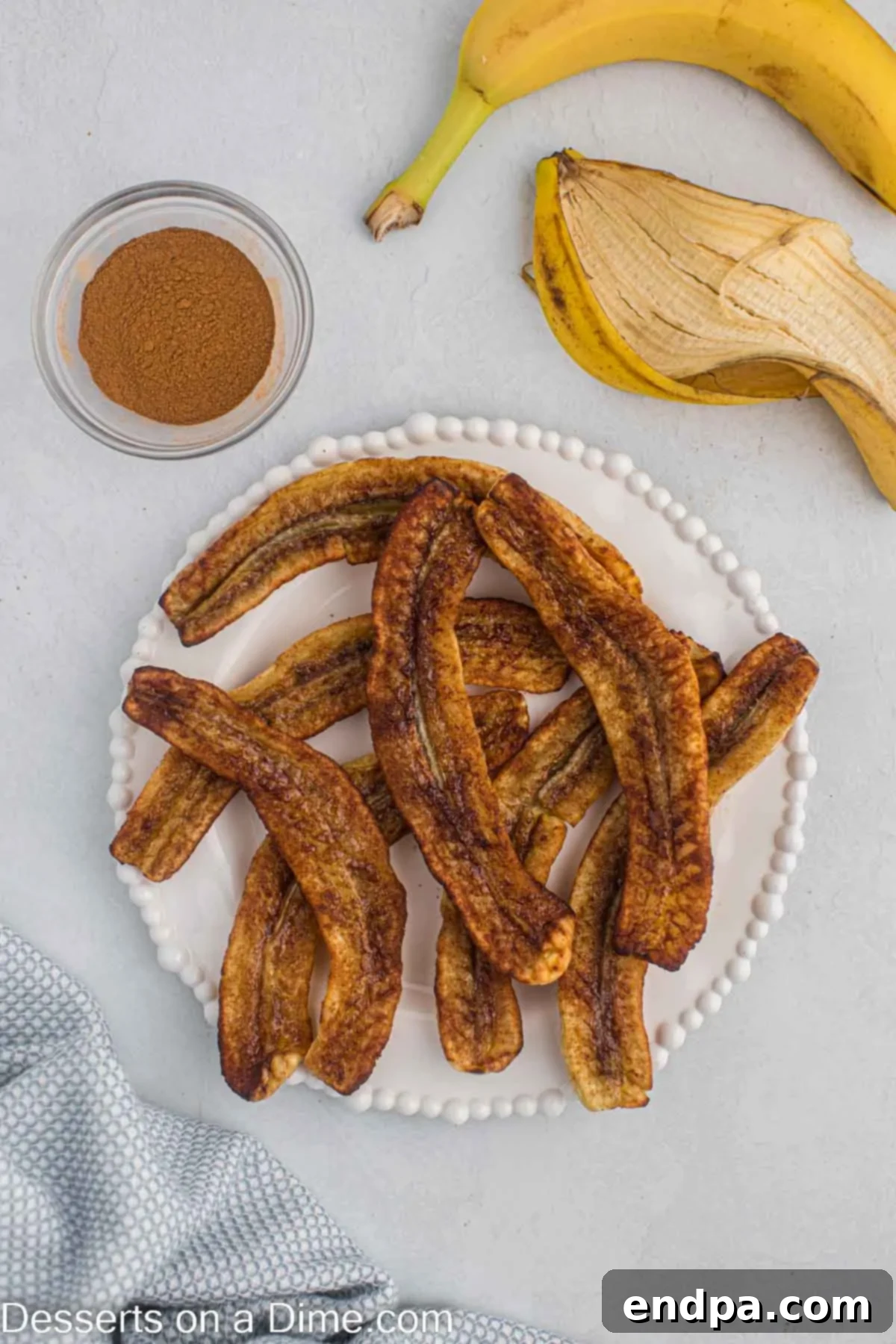 Banana slices arranged in a single layer in an air fryer basket, ready for cooking.