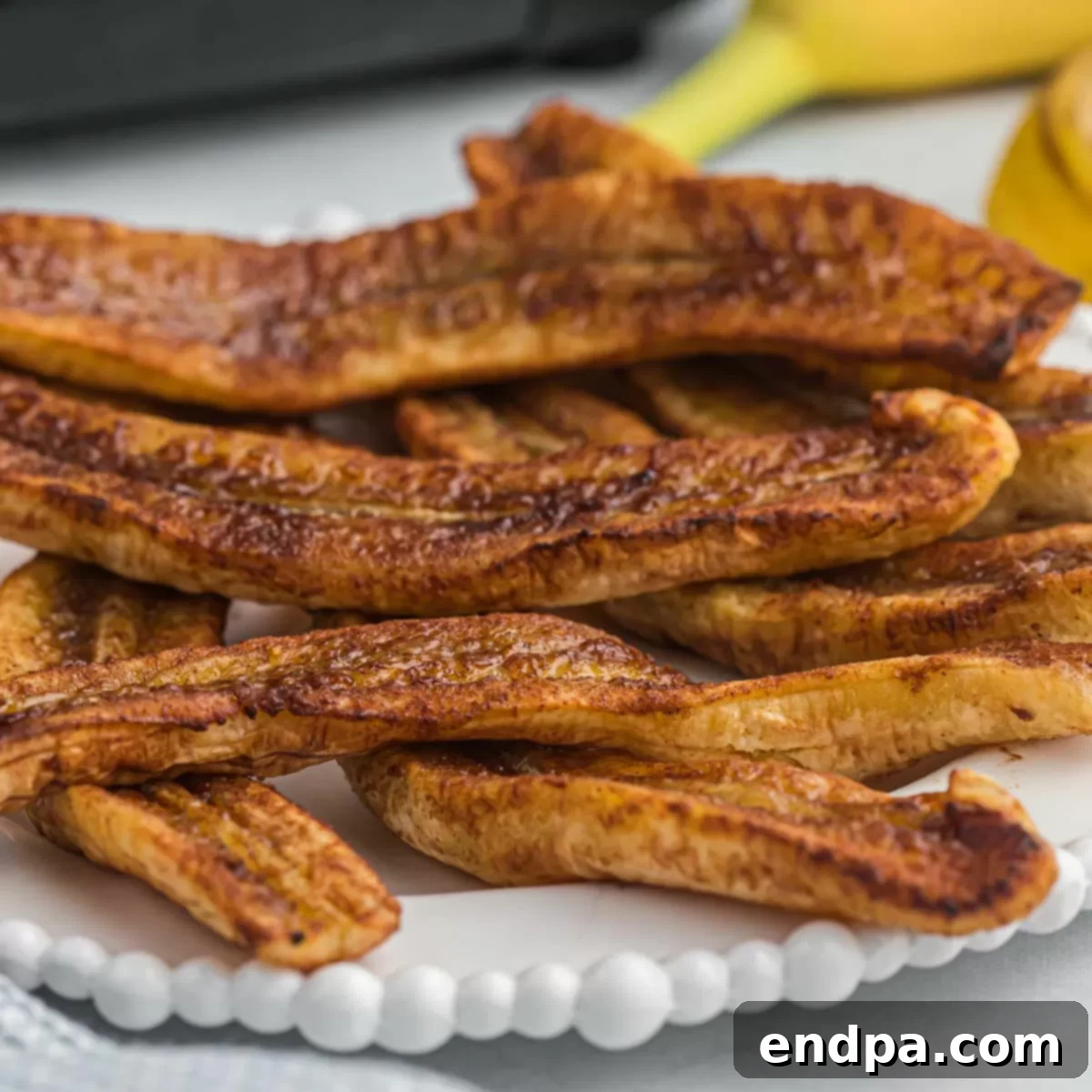 Air-fried banana slices on a white plate, ready to be served.