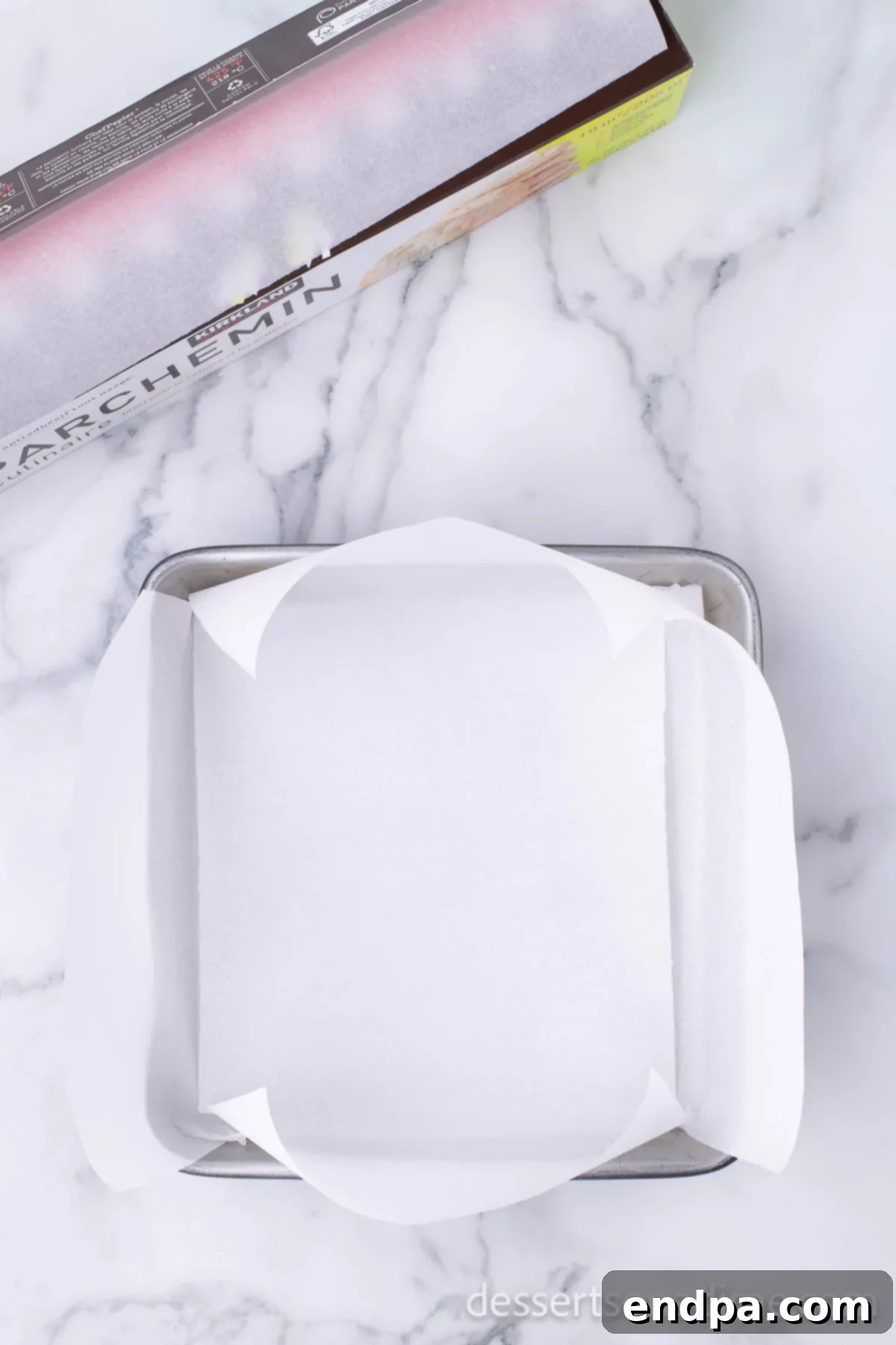 Easy Holiday Peppermint Bark 2 An 8x8 baking pan lined with wax paper, ensuring easy removal of the peppermint bark.