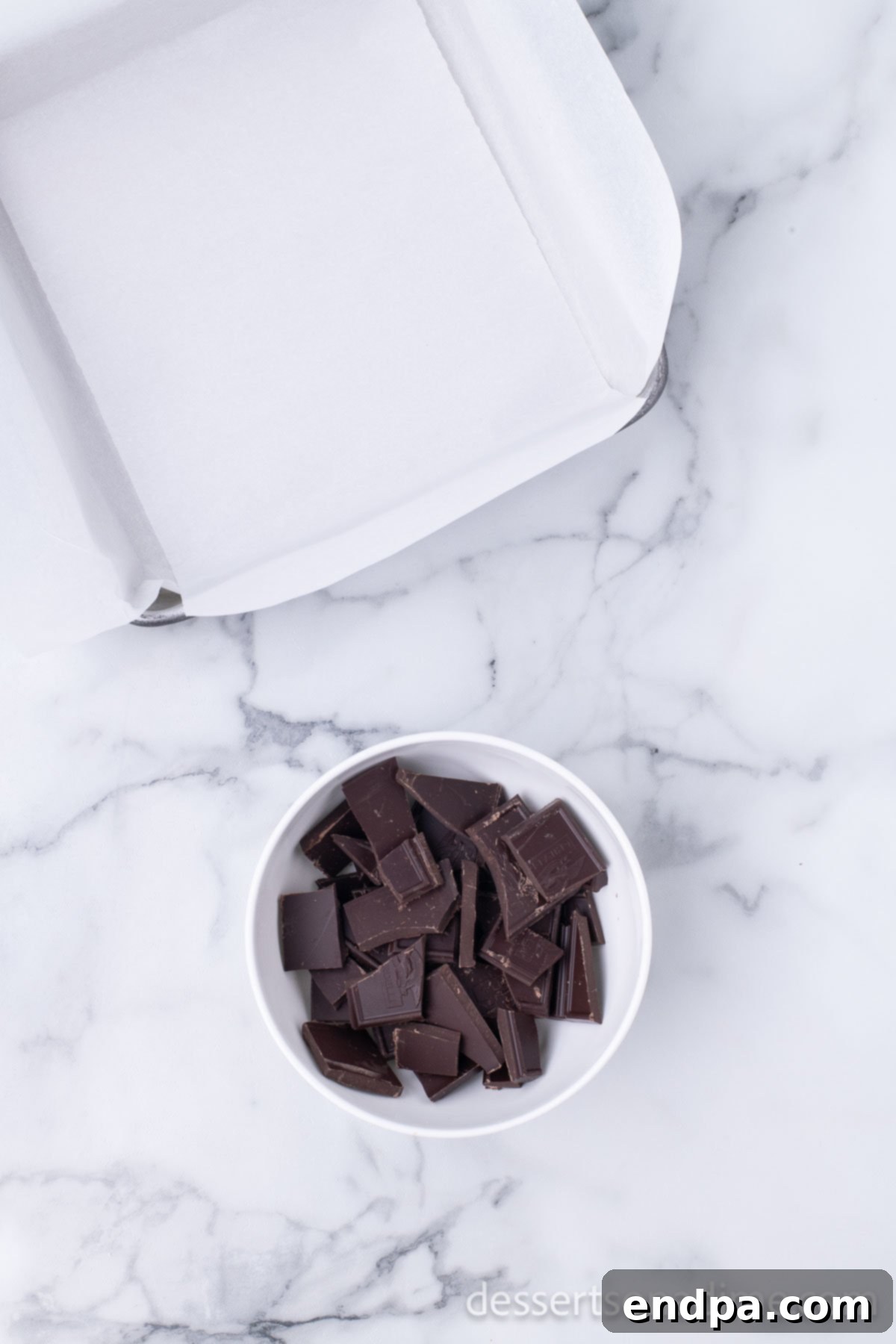 Easy Holiday Peppermint Bark 3 Finely chopped dark chocolate in a microwave-safe bowl, ready for gentle melting.