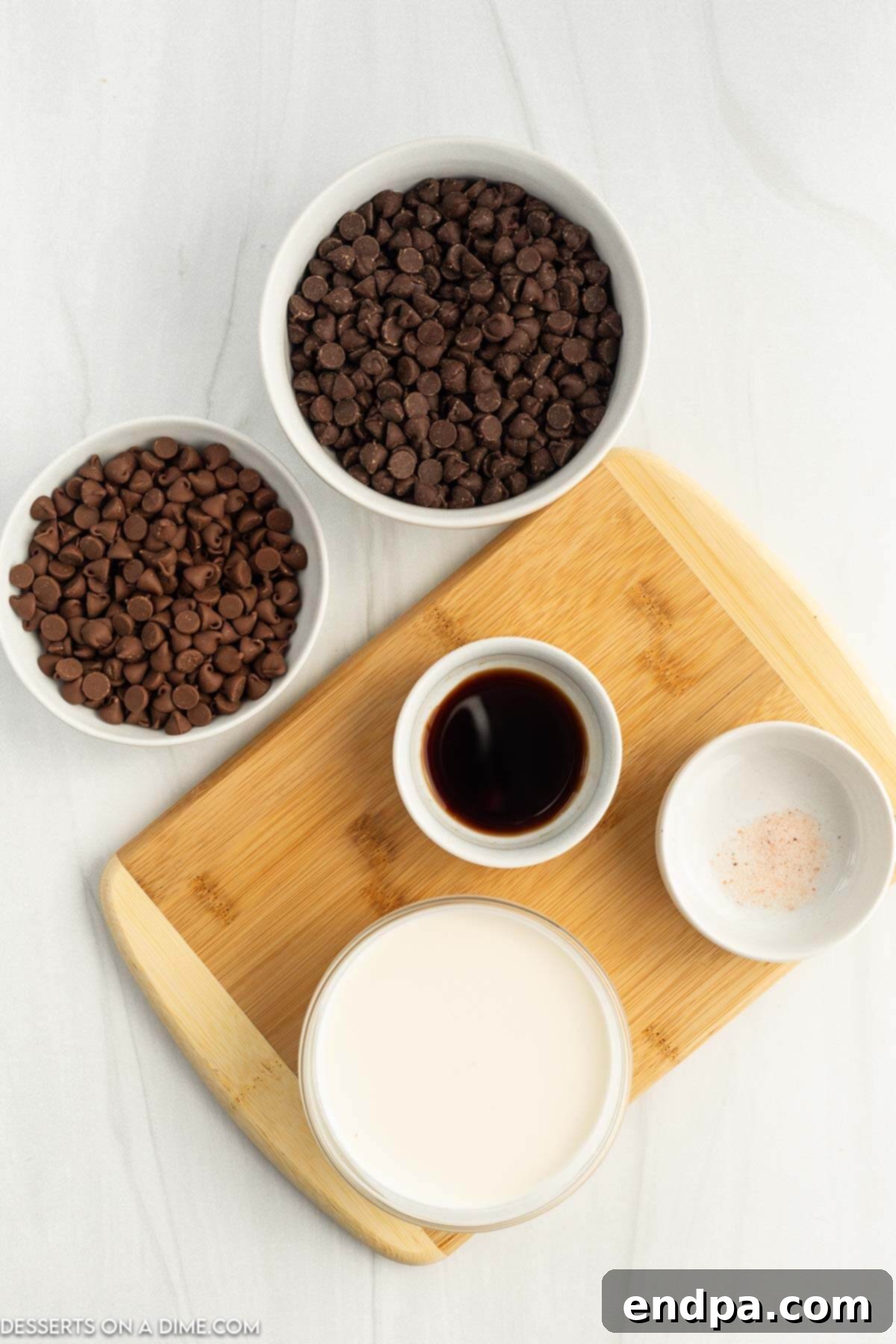 Ingredients for chocolate fondue: chocolate chips, heavy whipping cream, vanilla extract, and a pinch of salt, laid out with various dippers.