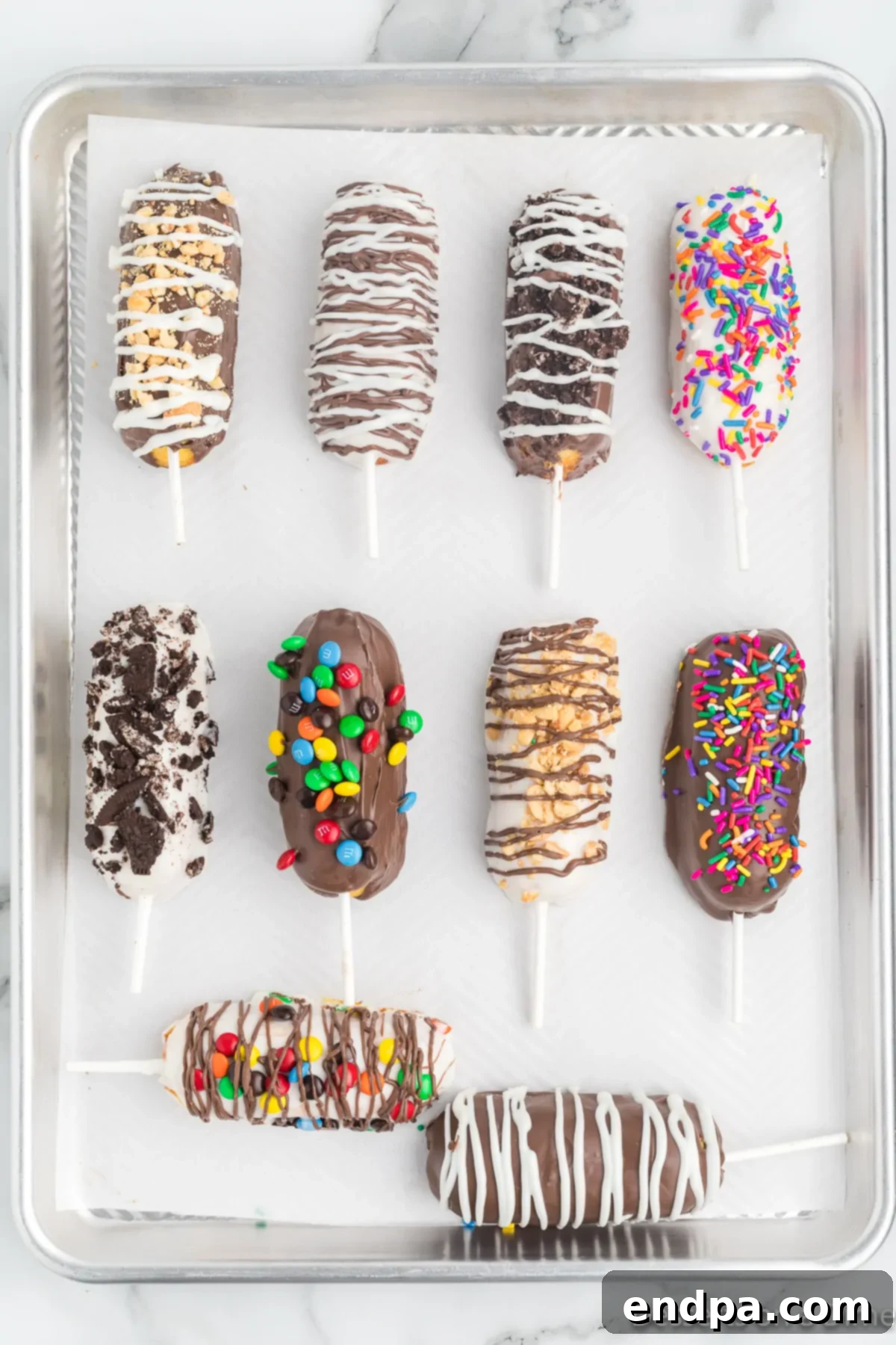 Decadent Chocolate Dipped Twinkies 7 Freshly chocolate-covered Twinkies, topped with a colorful assortment of sprinkles and small candies, arranged on a baking sheet to harden.