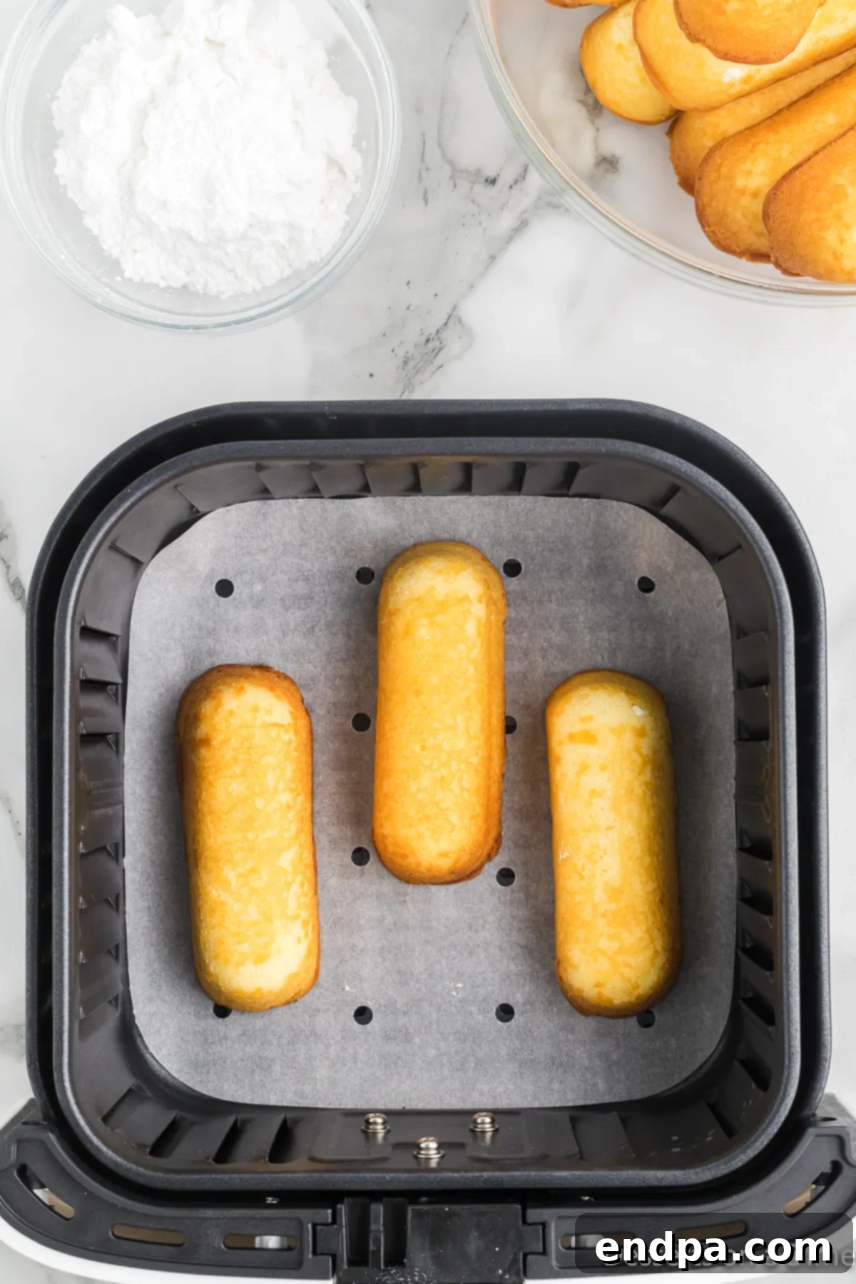 Twinkies carefully arranged in a single layer within the air fryer basket, ready for cooking.