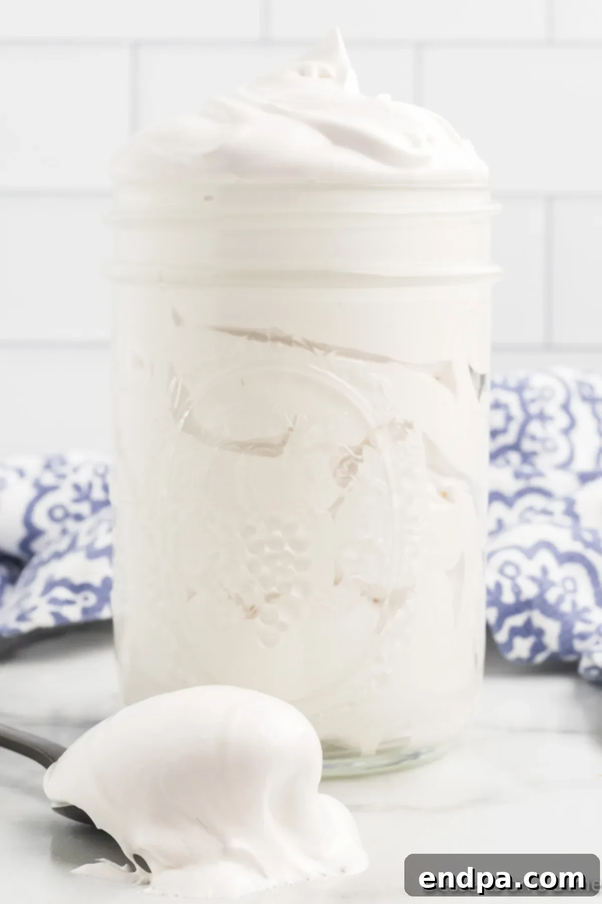 A beautiful jar overflowing with homemade marshmallow fluff, ready to be enjoyed.