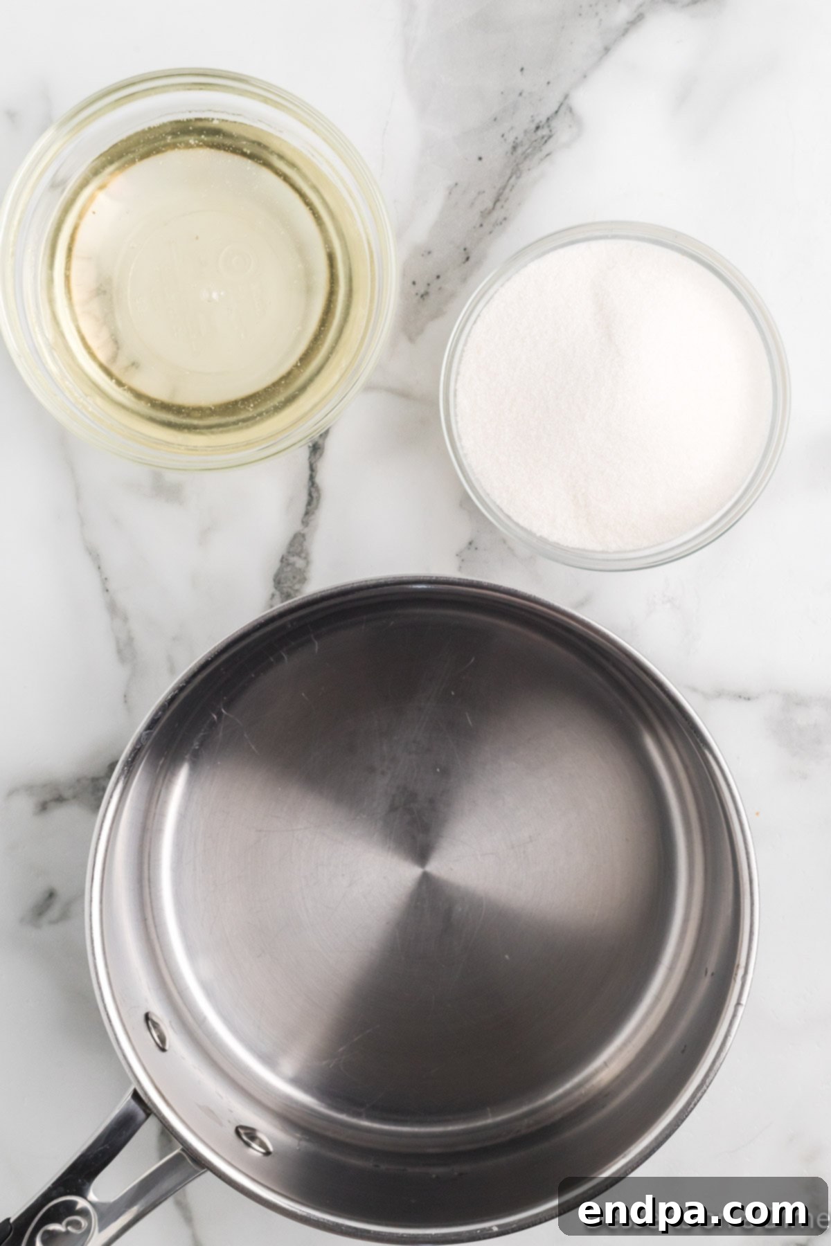 Saucepan on the stove with bowls of sugar and corn syrup on the side, ready for combining.