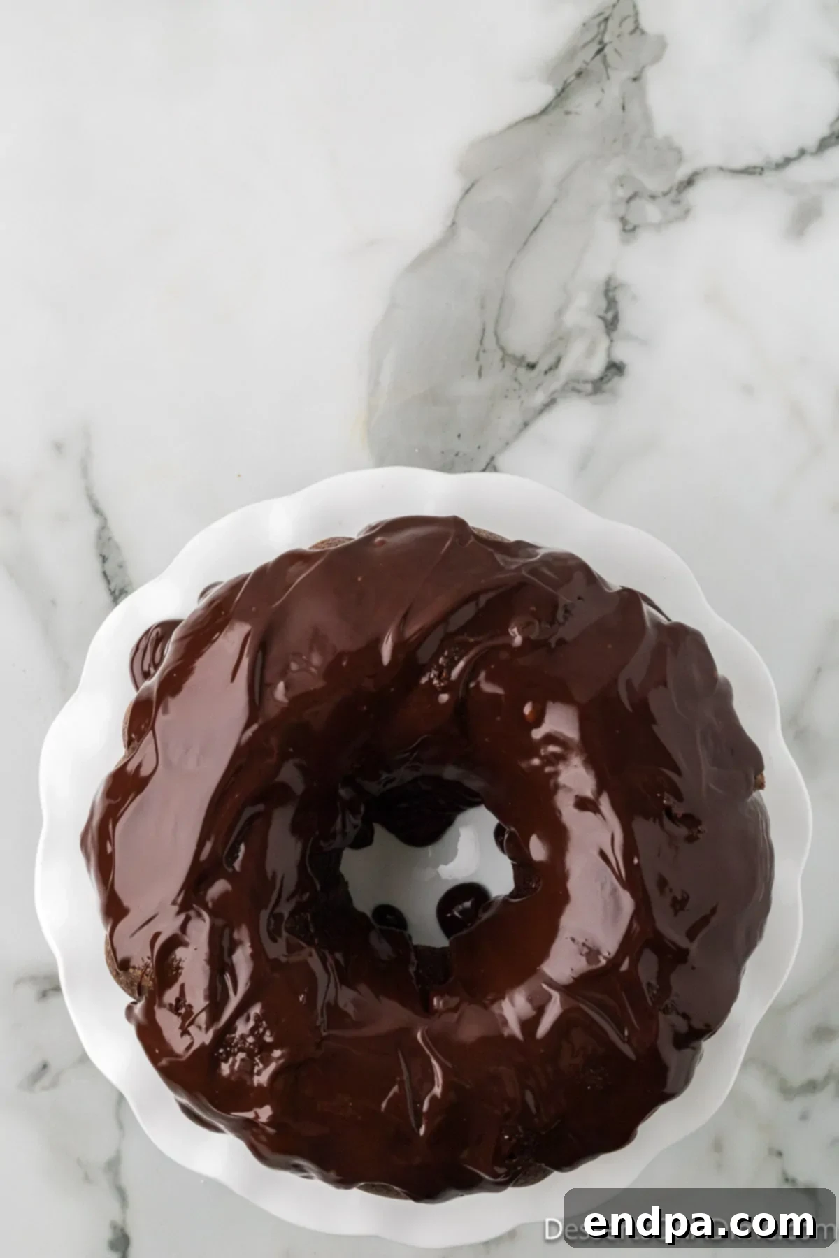 A slice of chocolate bundt cake with glaze, ready to be enjoyed.