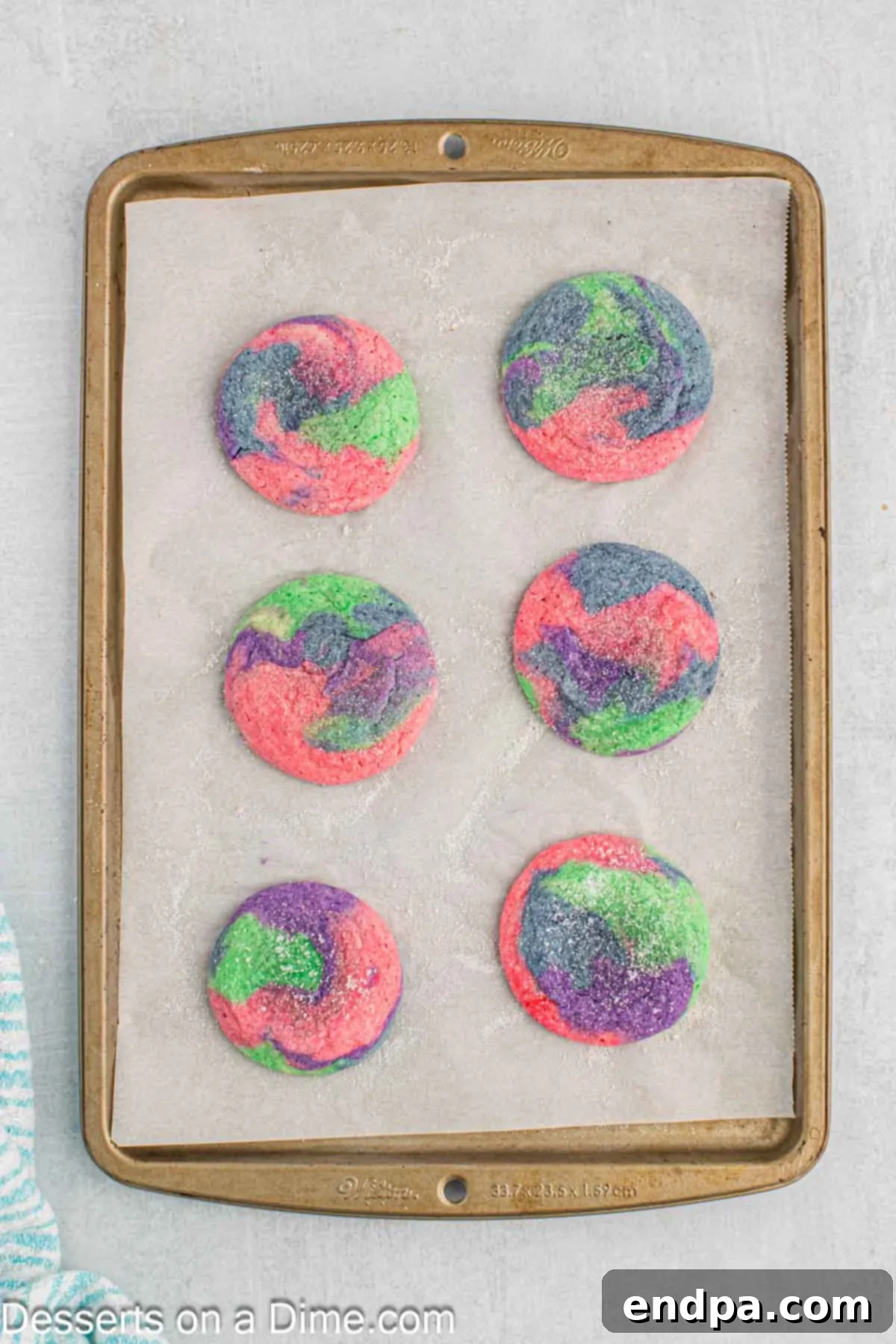 Enchanted Unicorn Treats 11 Freshly baked unicorn sugar cookies with cracked tops, resting on a baking sheet.