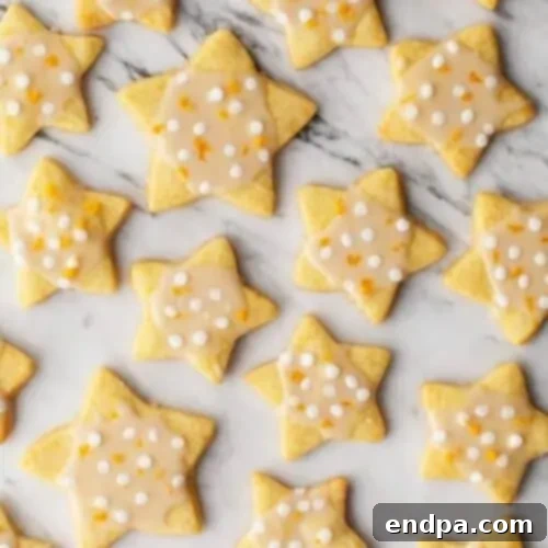 Star-shaped orange shortbread cookies with a delicate orange glaze, artfully arranged.