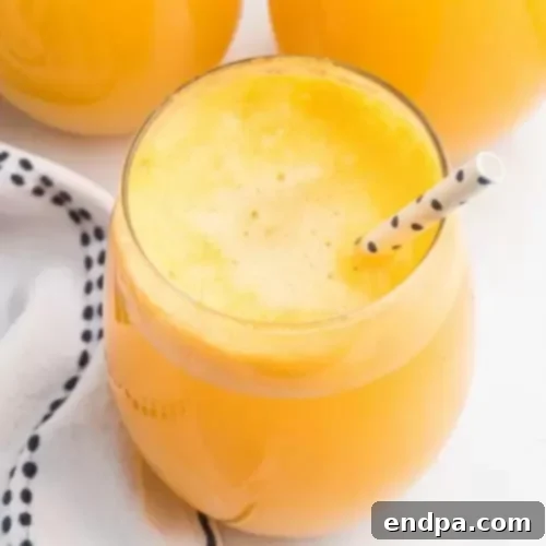 Two glasses filled with vibrant orange sherbet punch, garnished with orange slices and straws, ready for a party.