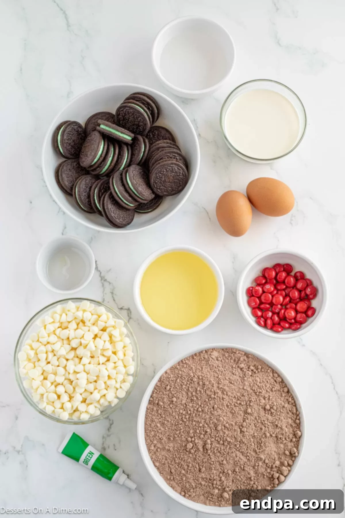 Grinch Green Brownies 3 Ingredients for Grinch Brownies including brownie mix, white chocolate chips, mint Oreos, red M&M's, heavy cream, and peppermint extract.