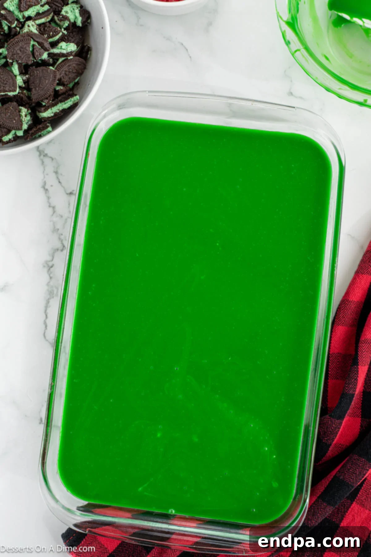 Grinch Green Brownies 9 Vibrant green ganache spread smoothly over the baked brownies in a baking pan.