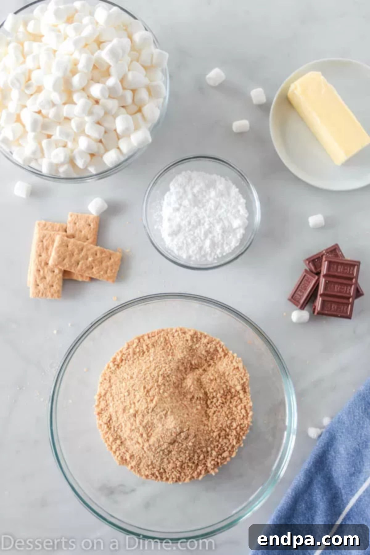 S'mores cookie cups are bite size treats with everything you love about s'mores. Make these mini s'mores bites with only 5 ingredients for a tasty recipe. Ingredients needed for S'mores Cookie Cups: graham cracker crumbs, powdered sugar, butter, mini marshmallows, and chocolate bars.