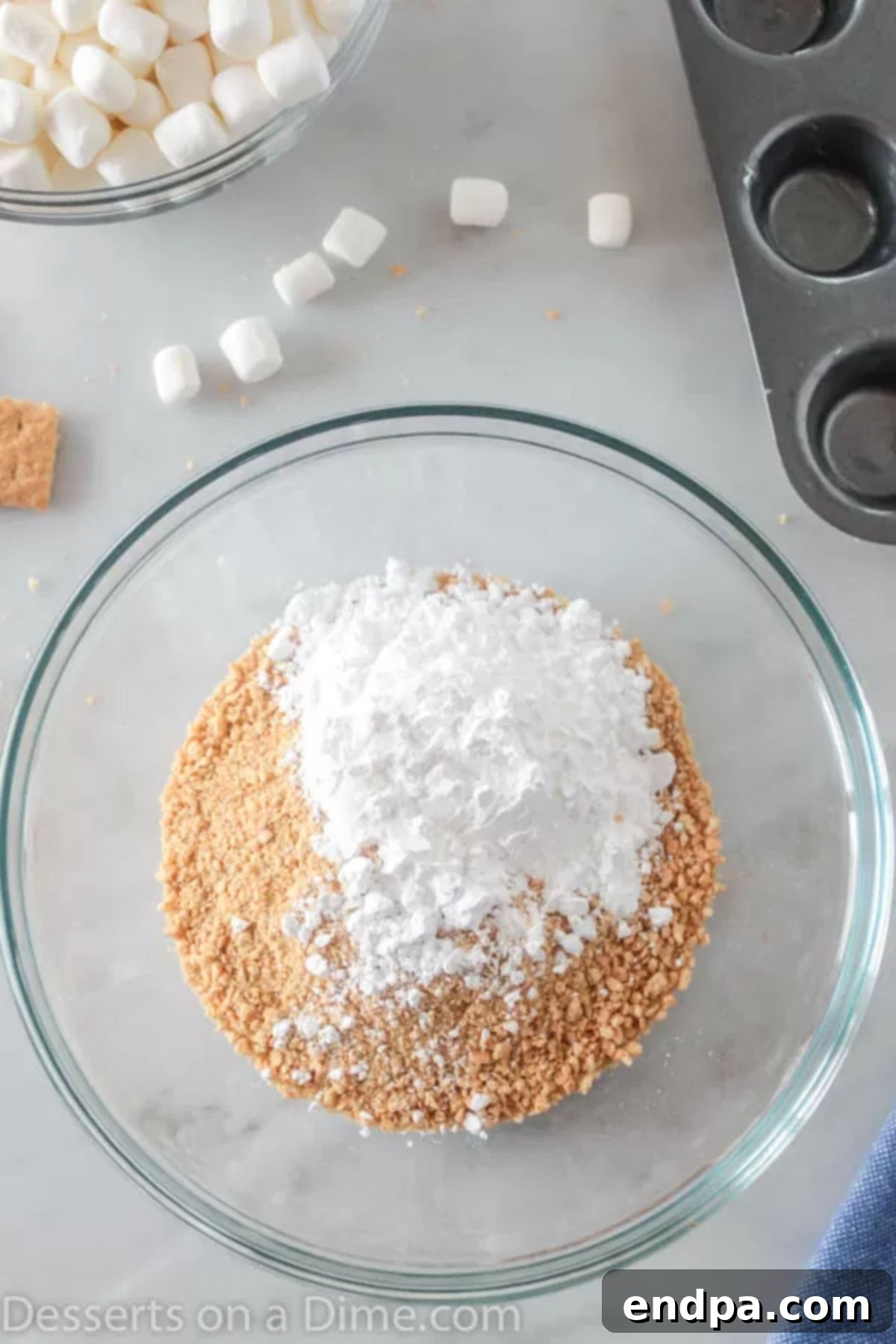Gooey S'mores Cookie Bites 2 Bowl containing a mixture of crushed graham crackers, powdered sugar, and melted butter, ready for the crust.