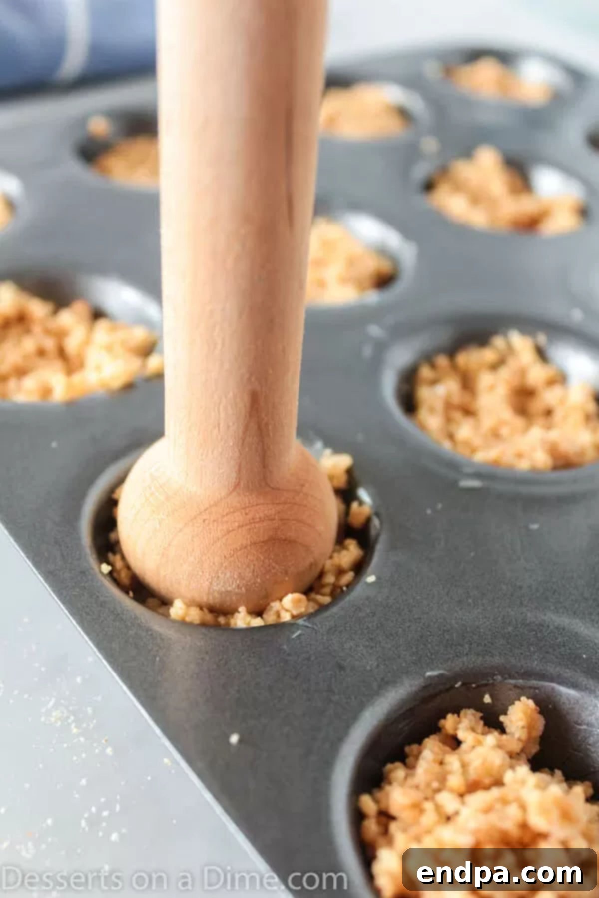 Gooey S'mores Cookie Bites 3 Mini muffin tin cups filled with the graham cracker crumb mixture, pressed down to form bases.