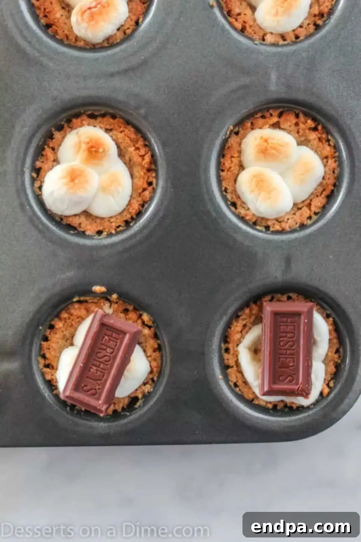 Gooey S'mores Cookie Bites 5 Melted chocolate squares placed on top of perfectly toasted marshmallows in each s'mores cookie cup.
