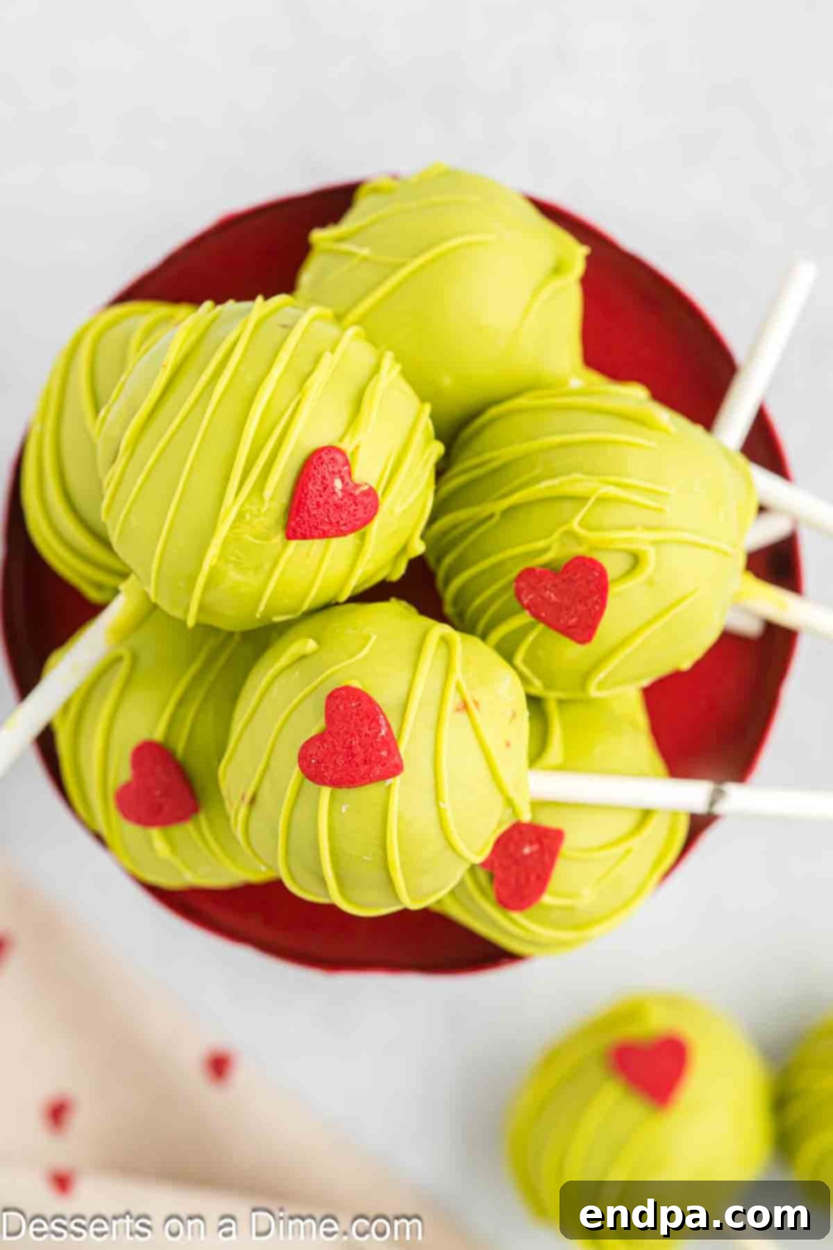Grinchmas Cake Pops 13 Grinch Cake Pops beautifully arranged on a platter, ready for a Christmas party.