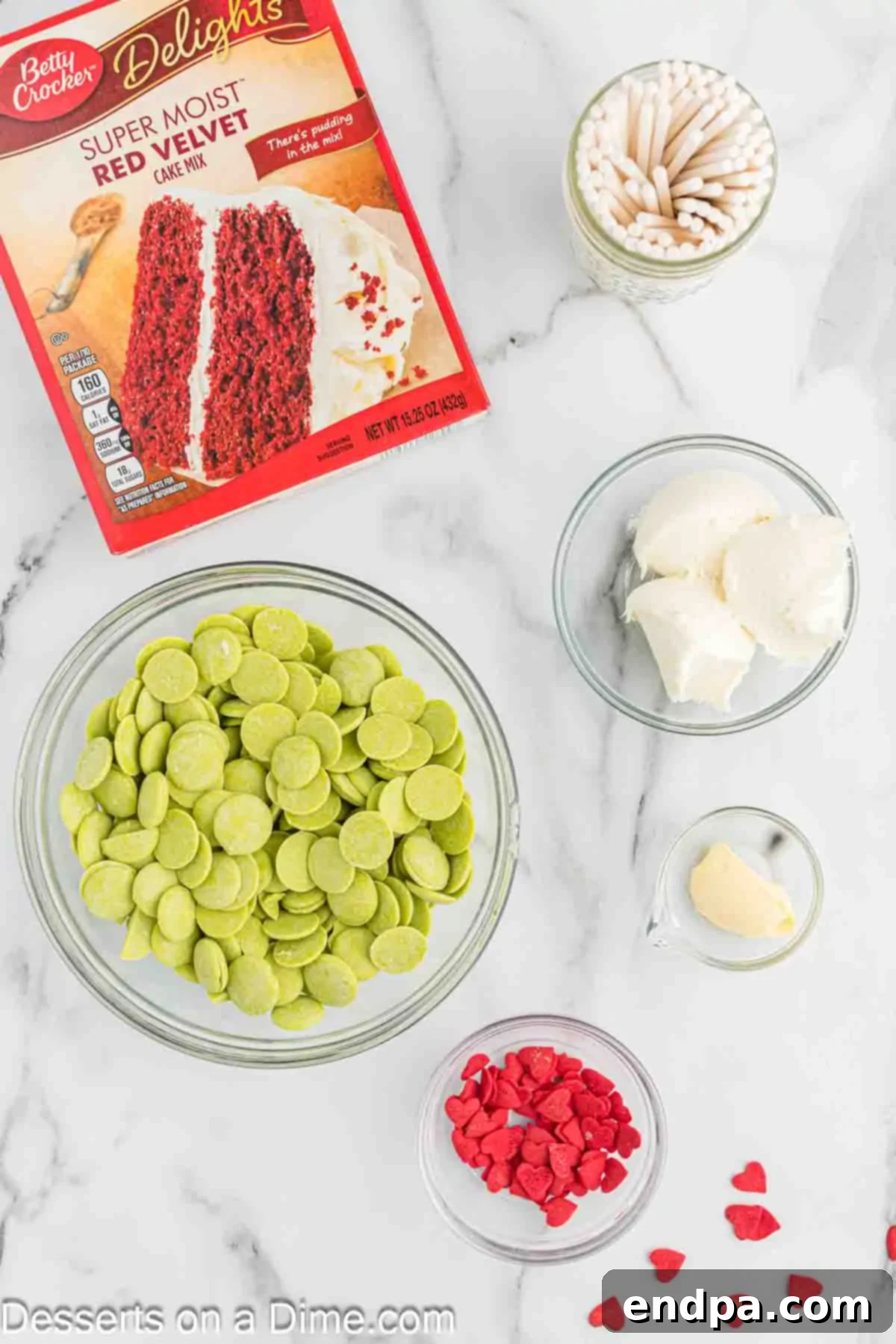 Grinchmas Cake Pops 3 Ingredients for Grinch Cake Pops: red velvet cake mix, cream cheese frosting, cake pop sticks, green candy melts, vegetable shortening, red candy hearts.