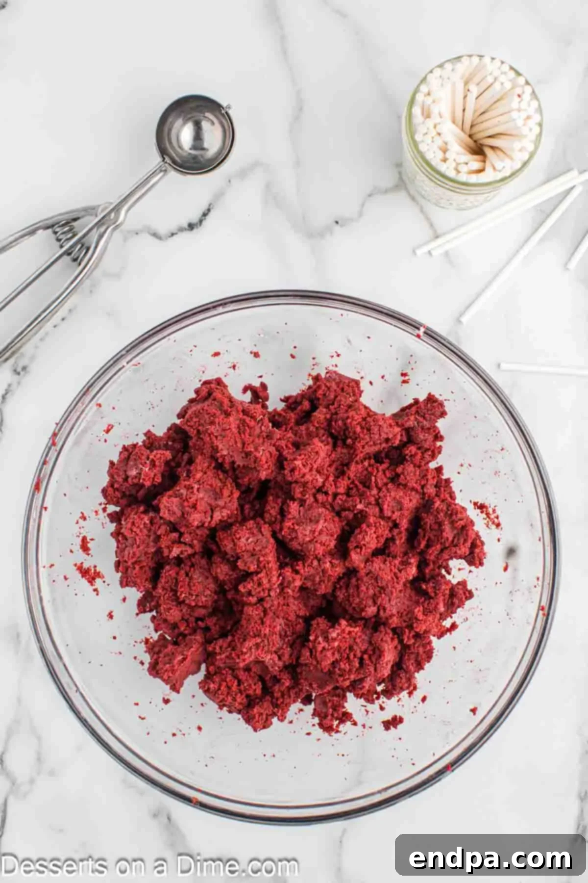 Grinchmas Cake Pops 6 Cream cheese frosting being mixed into the crumbled red velvet cake.