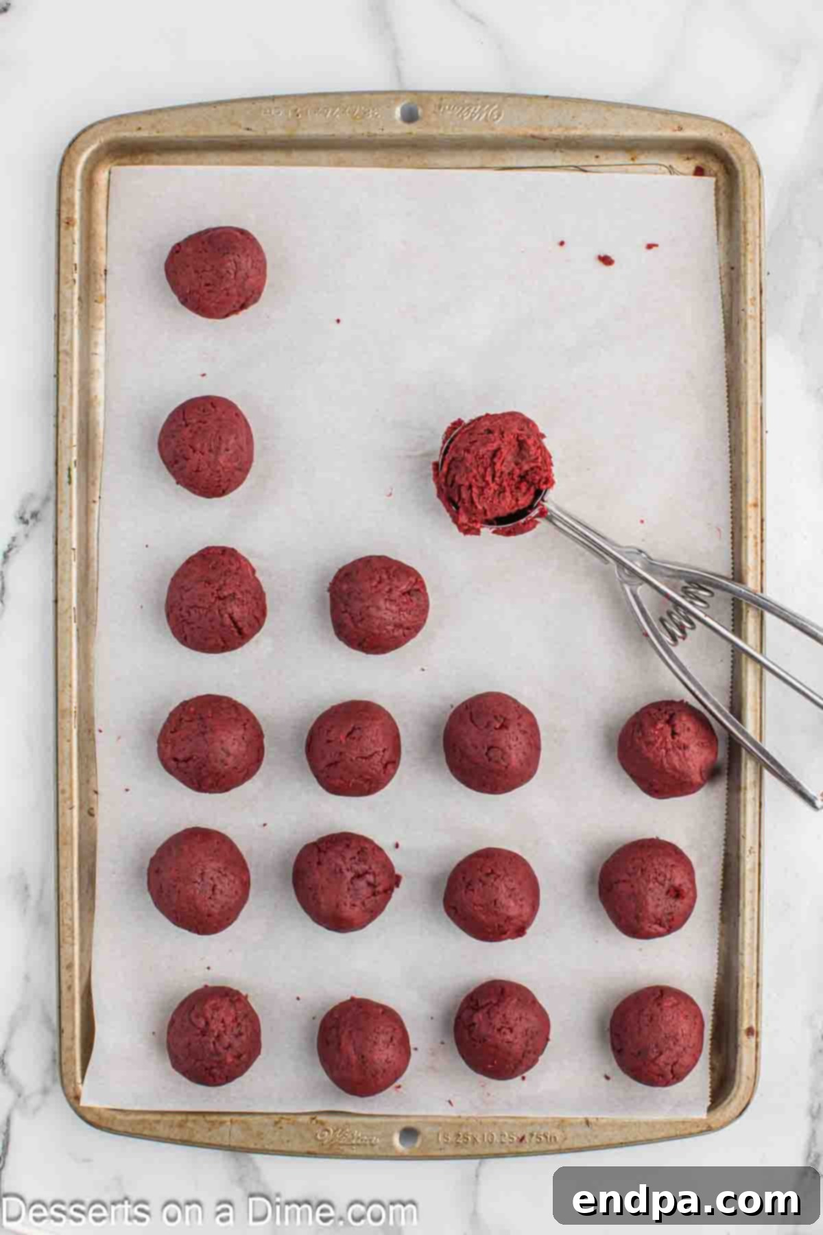 Grinchmas Cake Pops 7 Cake mixture being rolled into uniform balls on a lined baking sheet.