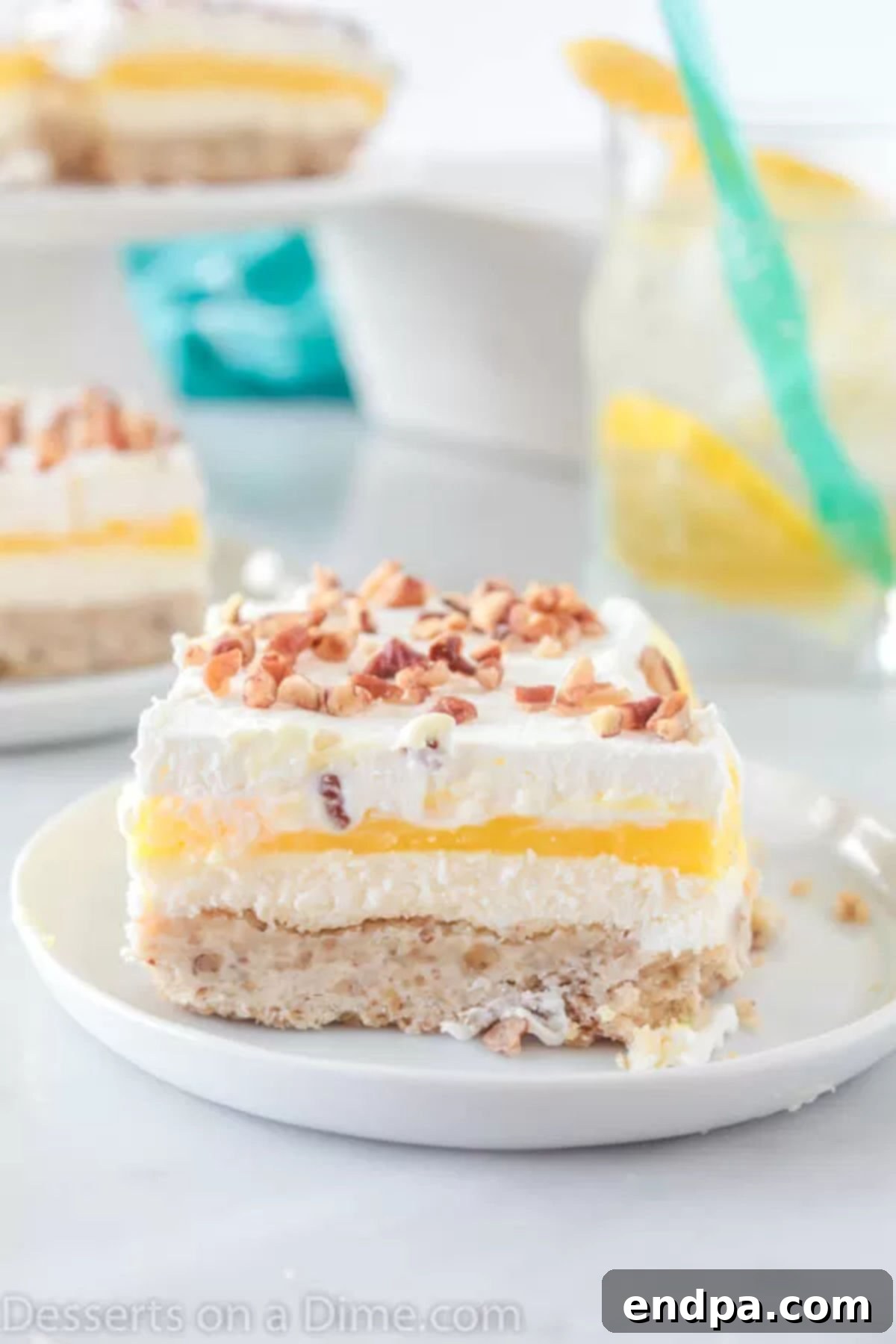 Close up image of a slice of Lemon Lush Dessert, showing its distinct layers.