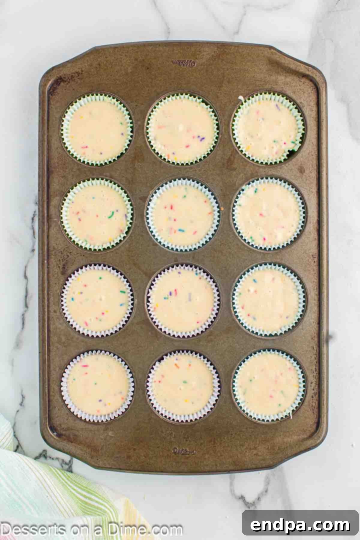 Cupcake liners filled with confetti batter, ready for baking.