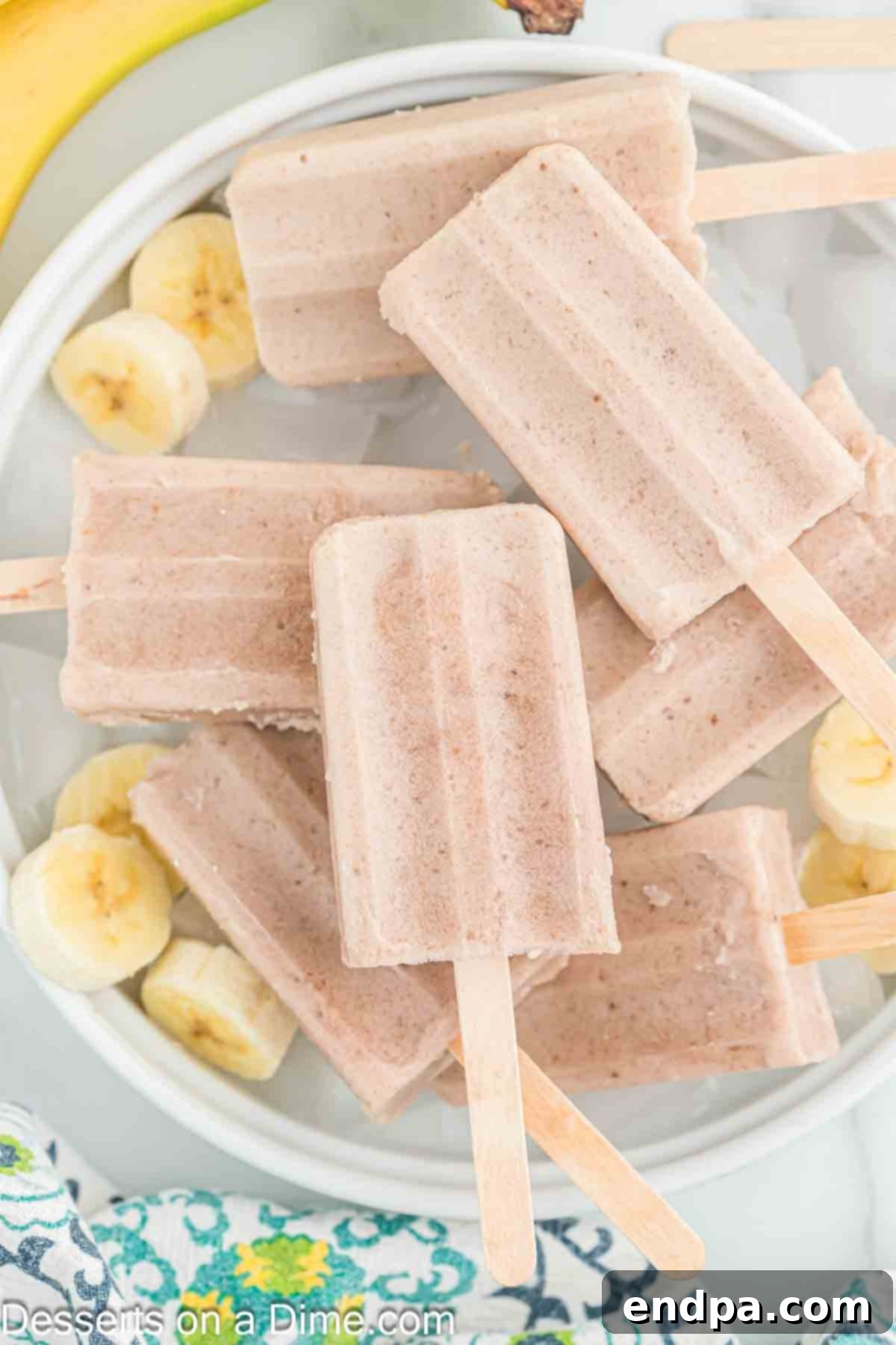 Frozen Banana Delights 2 Banana popsicles on a tray ready to serve.