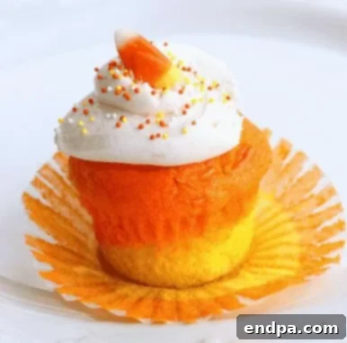 Candy corn themed cupcakes with yellow, orange, and white frosting layers.
