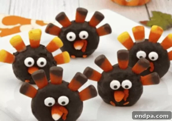 Turkey donuts decorated with candy feathers and eyes, on a white plate.