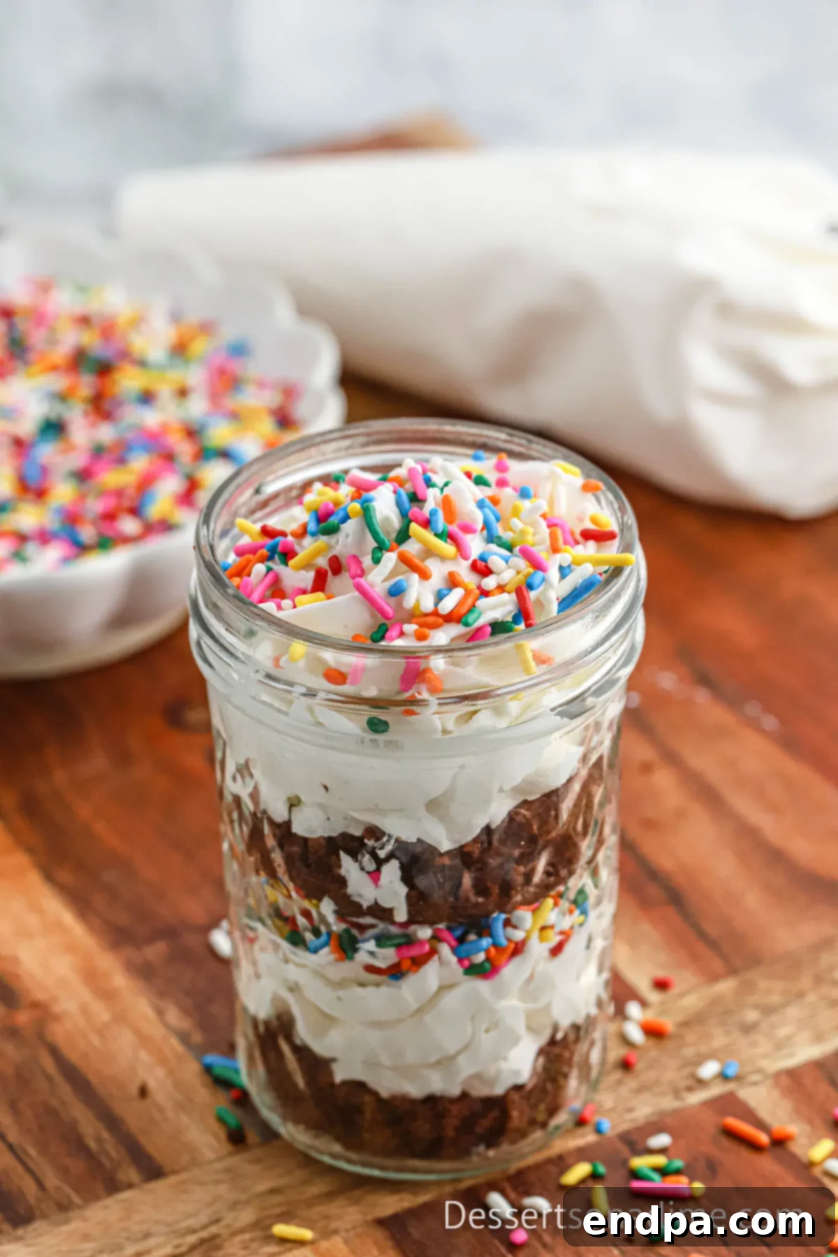 Portable Cupcake Perfection 12 Finished cupcake in a mason jar, beautifully layered with cake and icing, ready to eat.