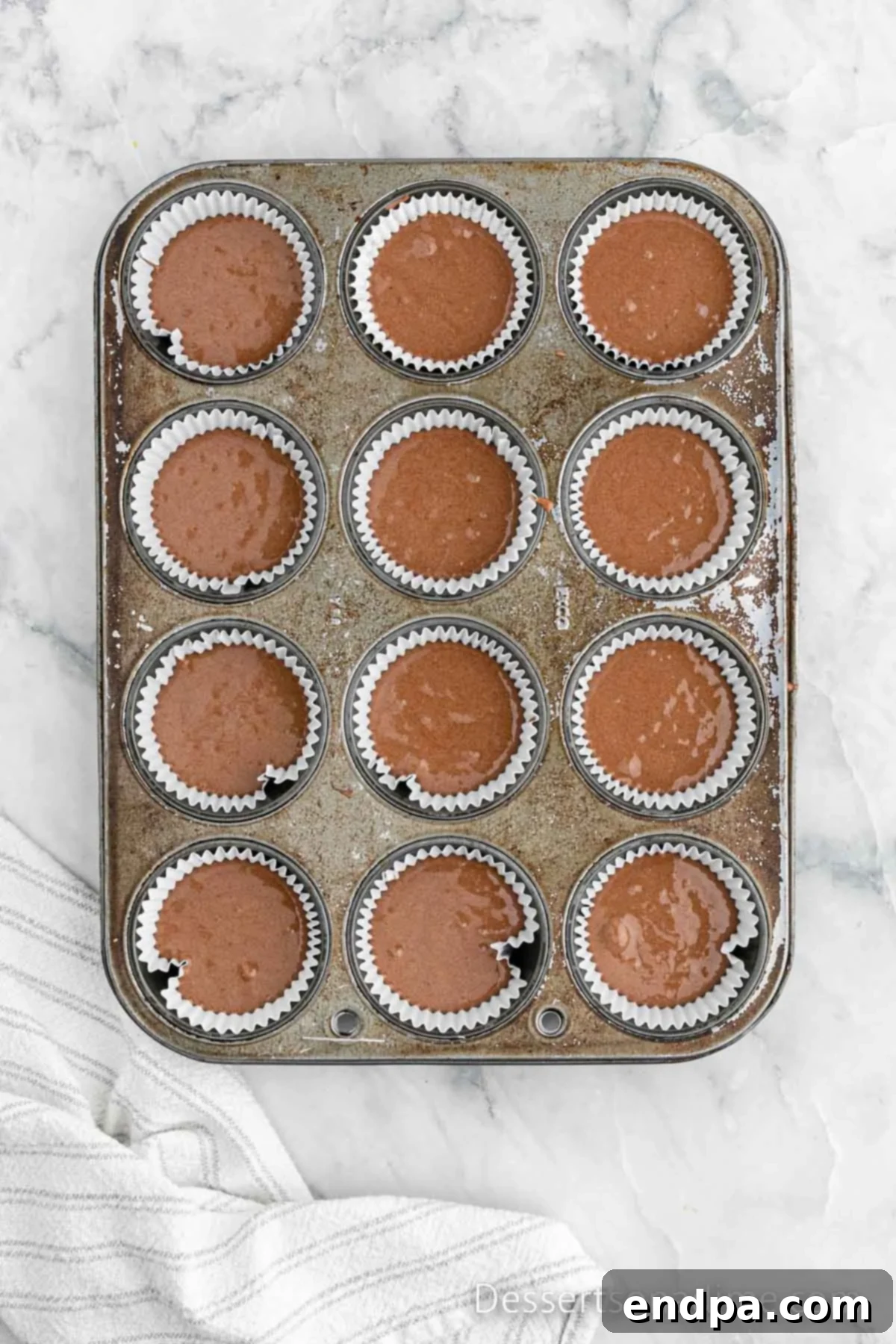 Portable Cupcake Perfection 4 Cupcake batter carefully poured into muffin tins, ready for baking.