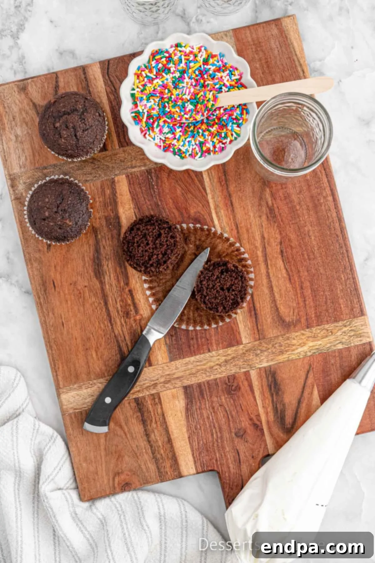 Portable Cupcake Perfection 7 Cooled cupcakes, with their tops carefully sliced off and separated from the bases.