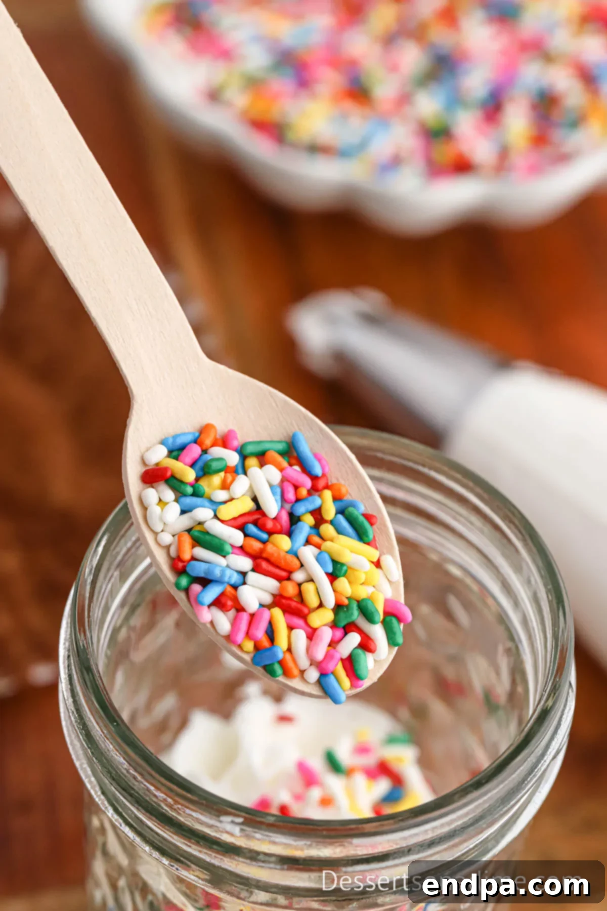 Portable Cupcake Perfection 9 A vibrant layer of sprinkles generously applied over frosting in a mason jar.