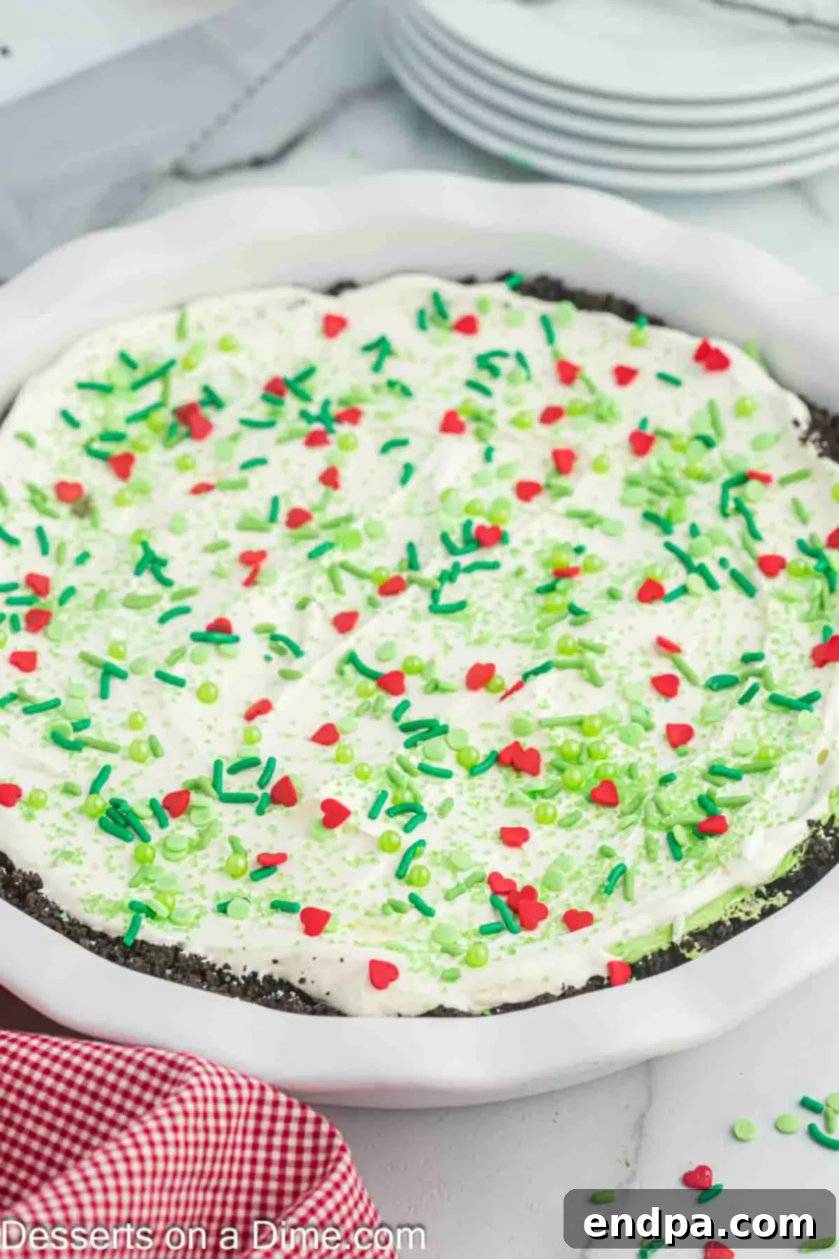 A whole Grinch pie on a serving plate, beautifully decorated.