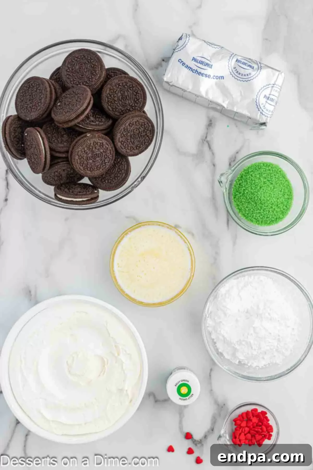 Ingredients for Grinch pie laid out: Oreo Cookies, butter, cream cheese, powdered sugar, green food coloring, cool whip, sprinkles.