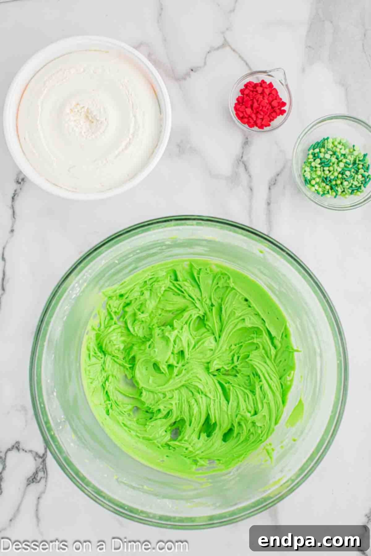 Adding green food coloring to the cream cheese mixture.