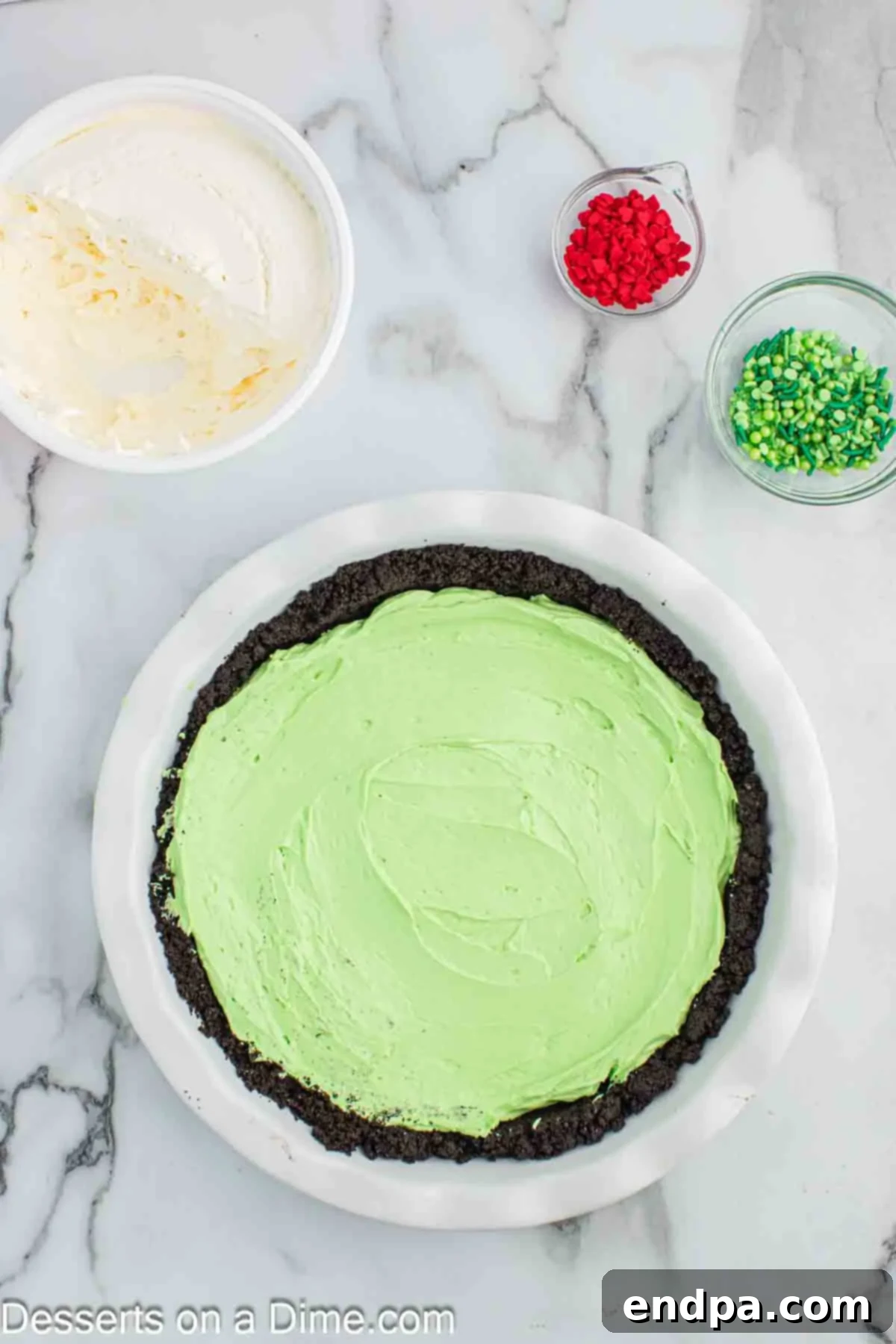 Spreading green pie filling into the Oreo crust.