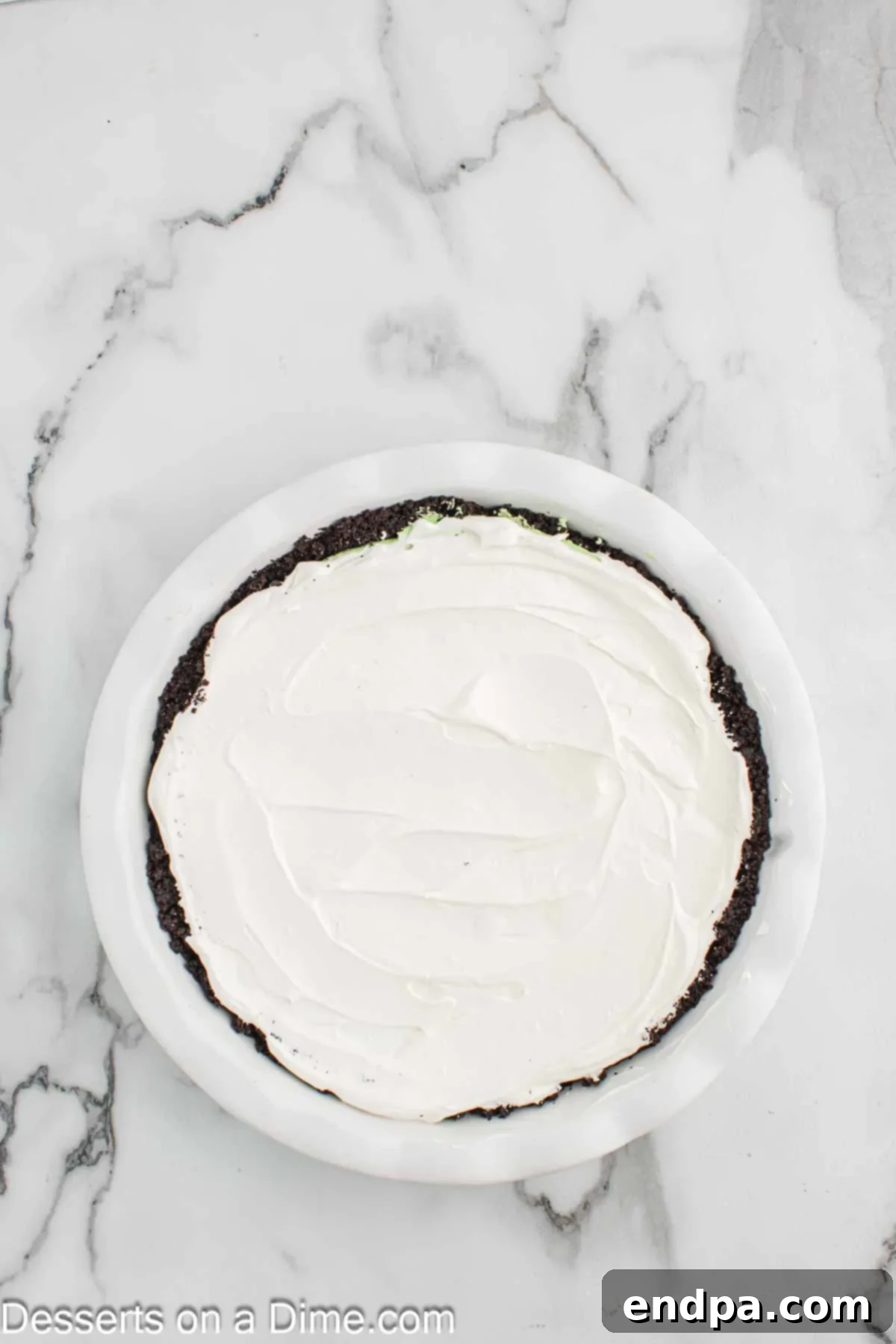 Spreading Cool Whip on top of the prepared pie.