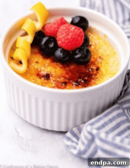 Elegant Lemon Crème Brulee with a crisp caramelized sugar topping, garnished with fresh berries.