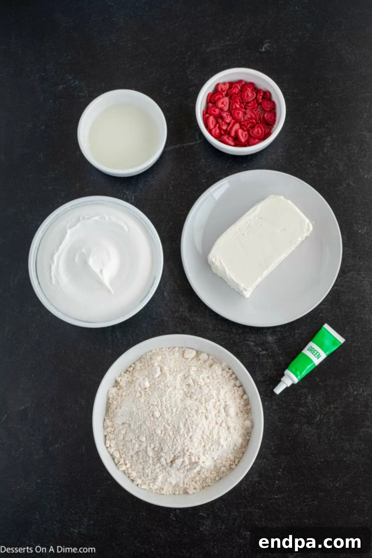 Heart-Growing Grinch Dip 3 Collection of ingredients for Grinch dip including a box of yellow cake mix, cream cheese, milk, green food coloring, and a tub of cool whip.