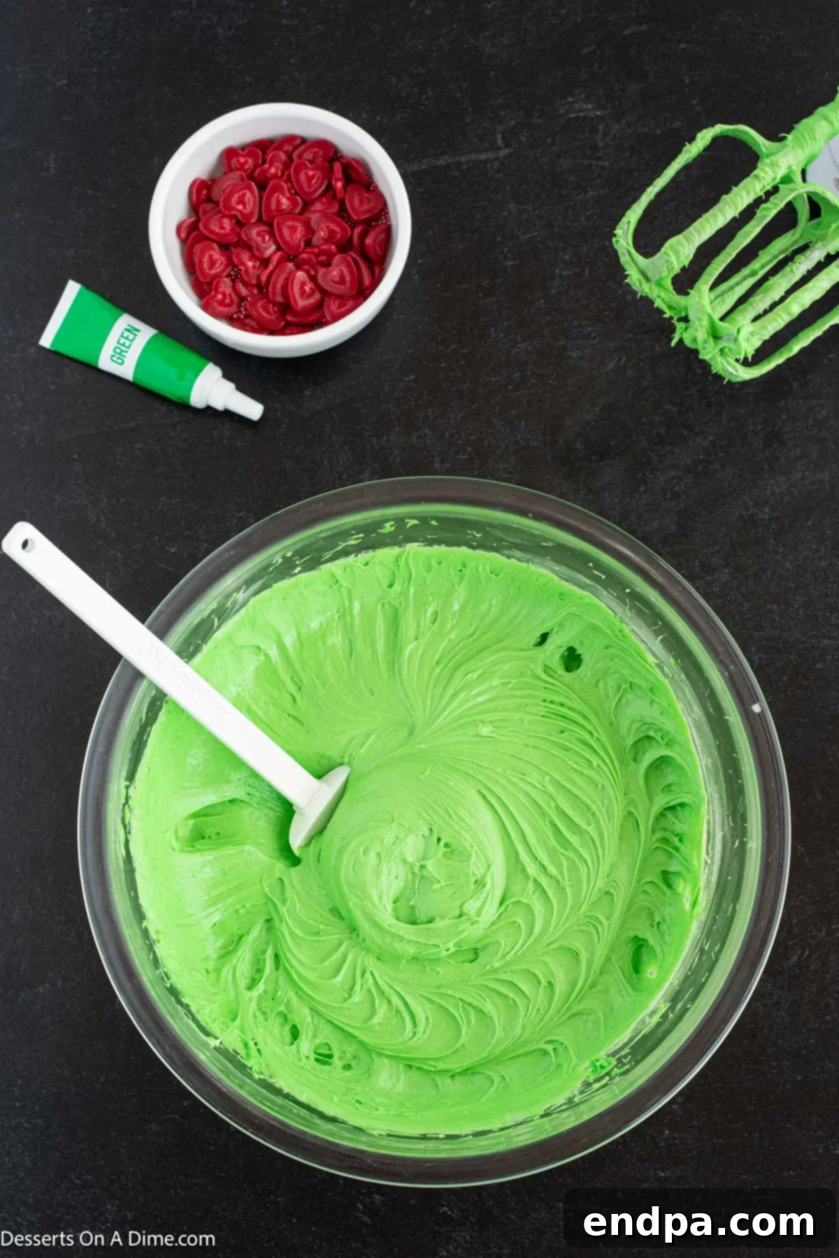 Heart-Growing Grinch Dip 5 Whipped topping, cream cheese, and milk being mixed together in a bowl.