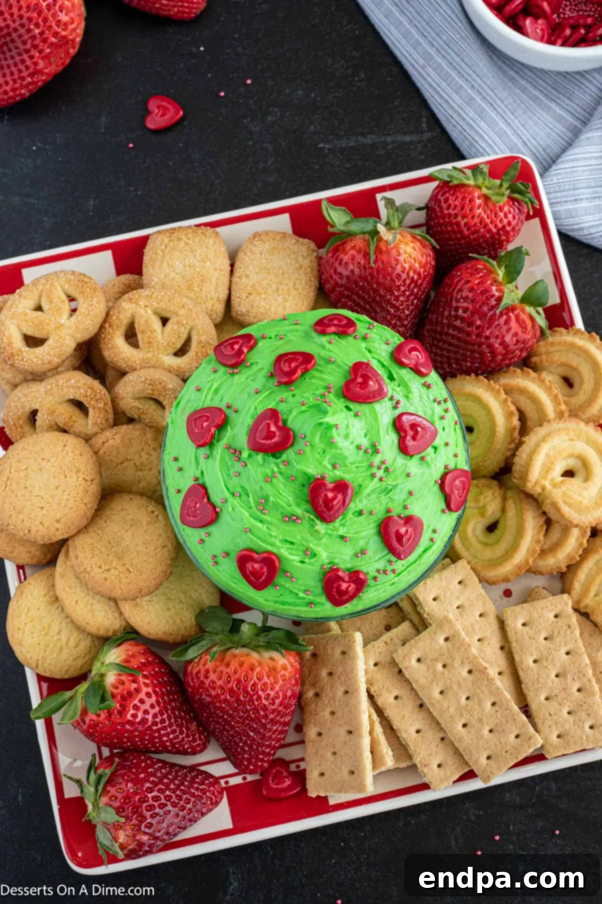 Heart-Growing Grinch Dip 6 Green food coloring being mixed into the dip to achieve the vibrant Grinch color.