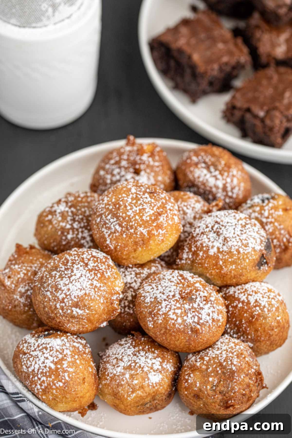Plate of Deep fried Brownie bites with powdered sugar. 