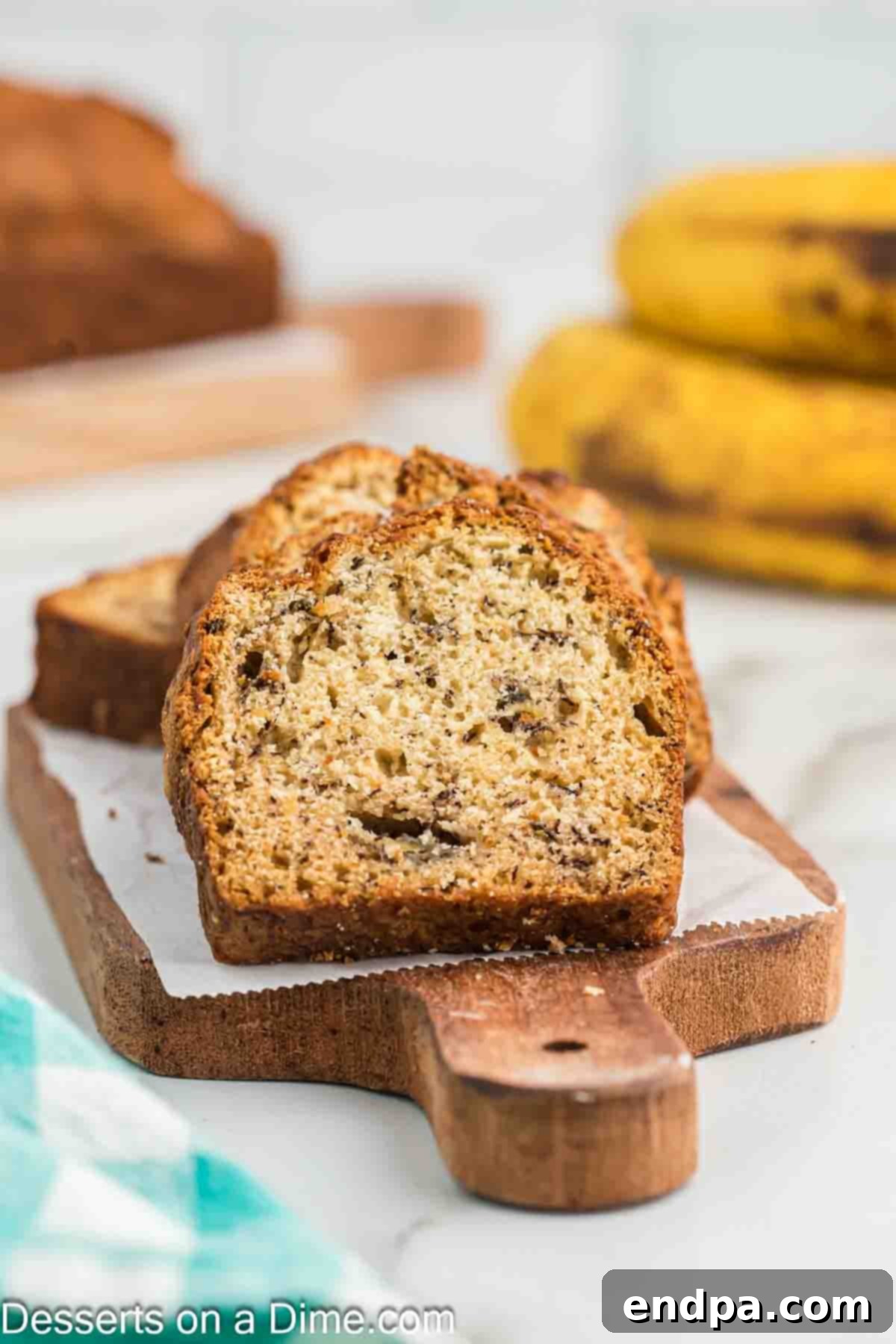 Golden Air Fryer Banana Loaf 2 Sliced Air Fryer Banana Bread ready to serve on a rustic wooden board.