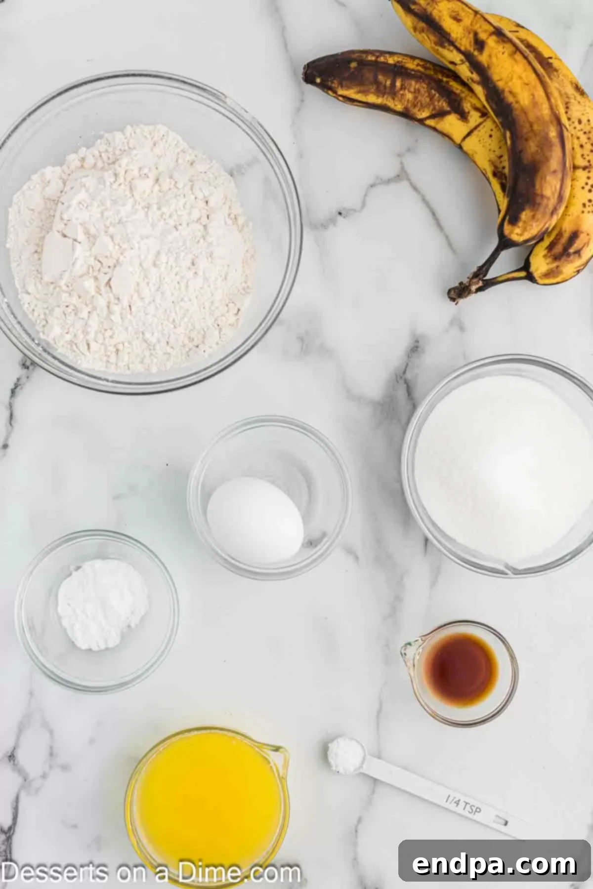 Golden Air Fryer Banana Loaf 3 Ingredients for banana bread laid out: ripe bananas, butter, eggs, sugar, flour, vanilla extract, baking soda, and salt.
