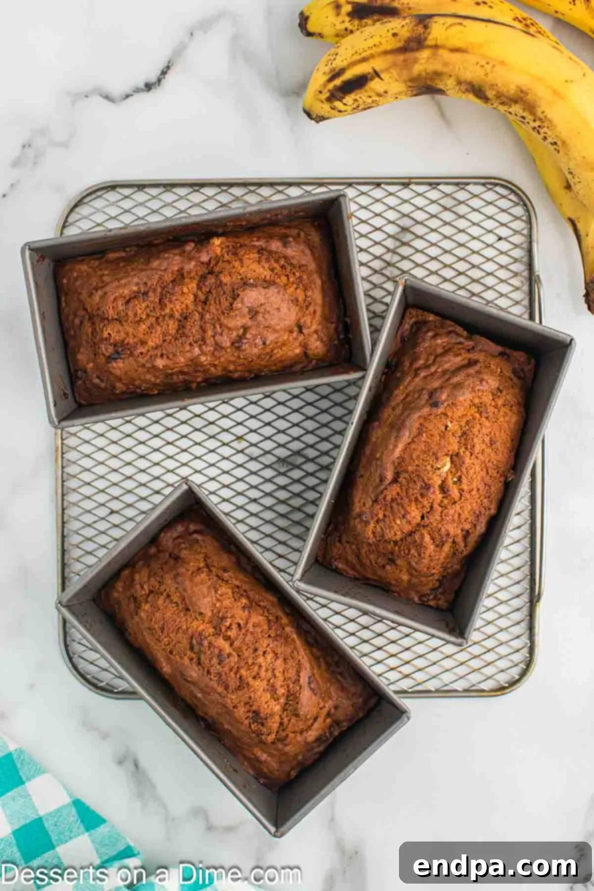 Golden Air Fryer Banana Loaf 7 Freshly baked mini banana bread loaves cooling on a wire rack.