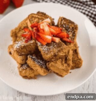 French toast sticks on a white plate with syrup.